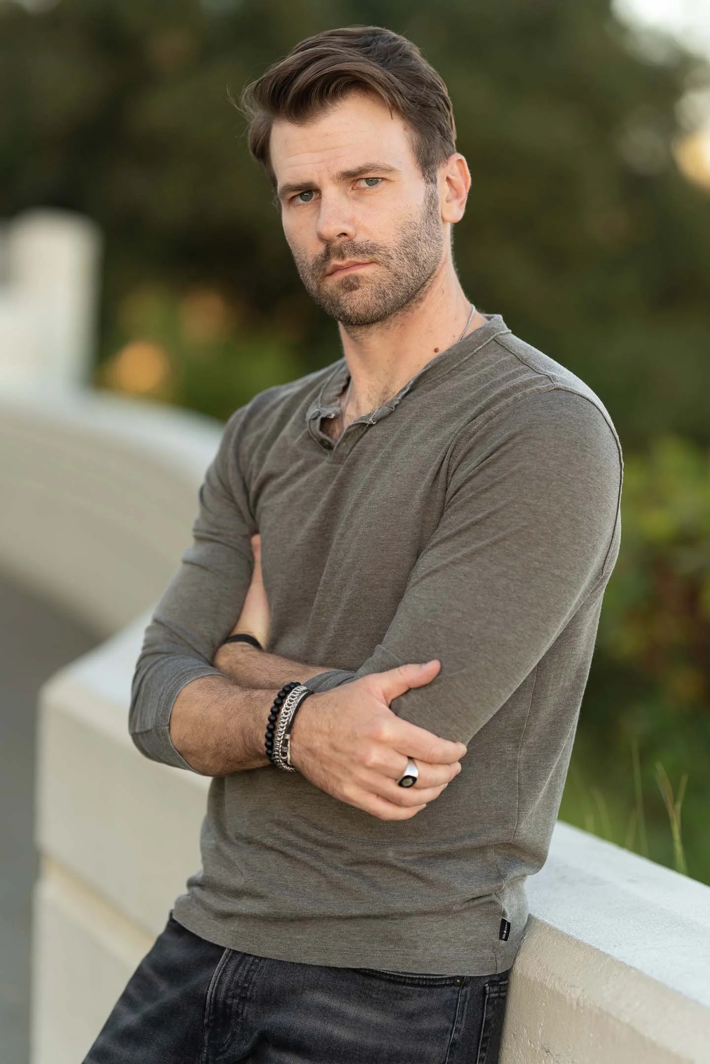 Man posing with green shirt behind grassy background