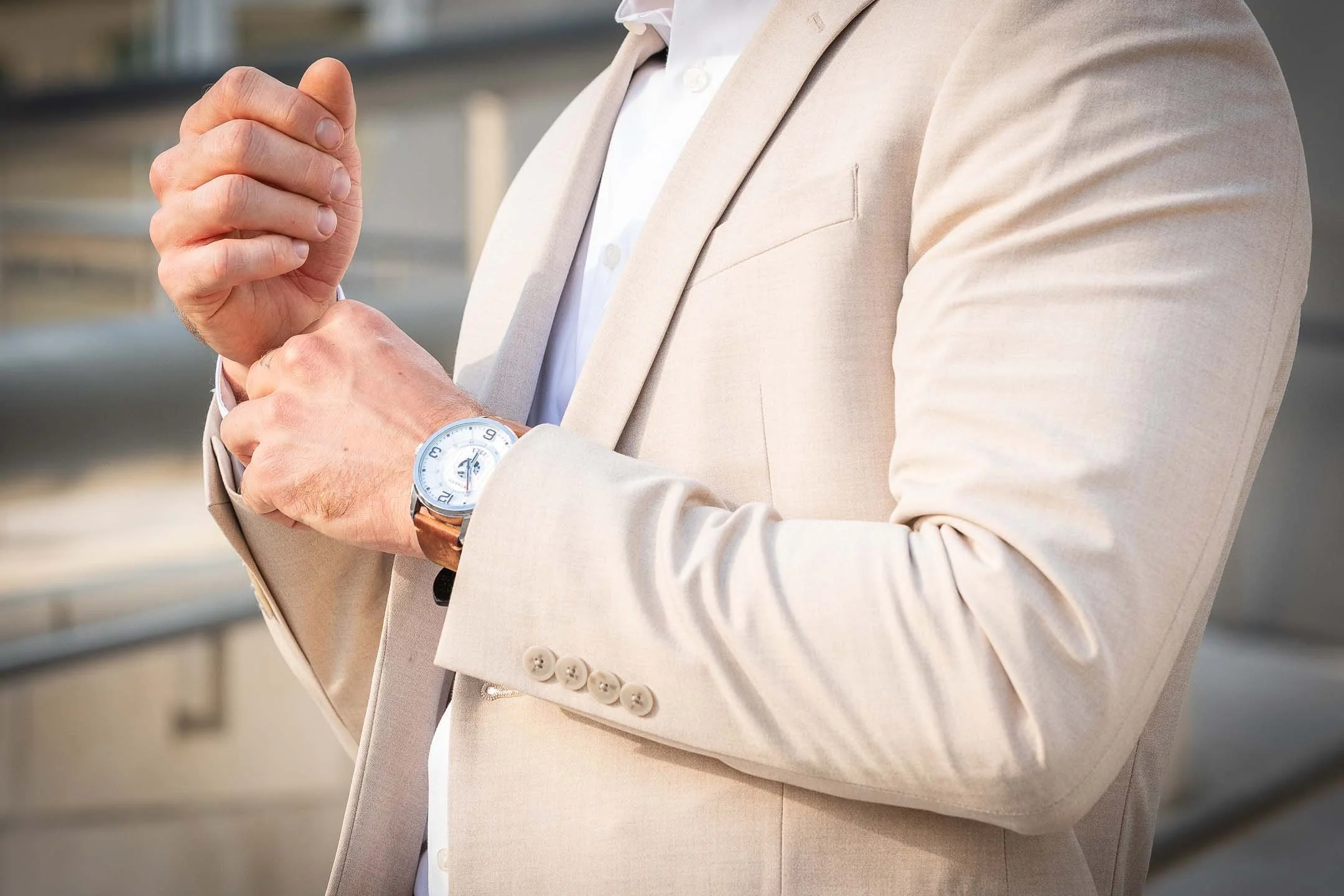 Male model fixing cuff wearing dress watch and business suit