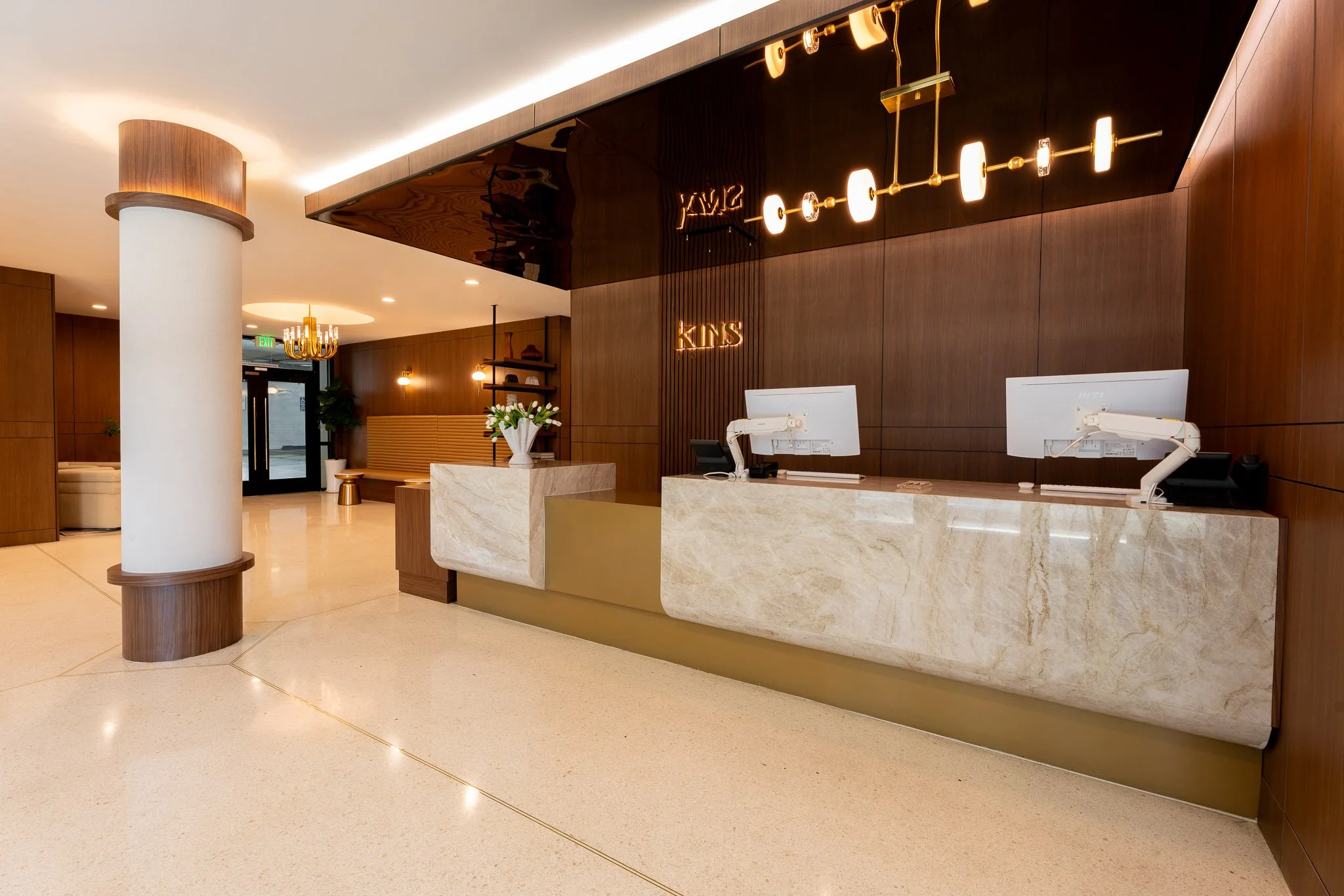 Wide angle of the Kins Hotel lobby with beautiful lights and computers