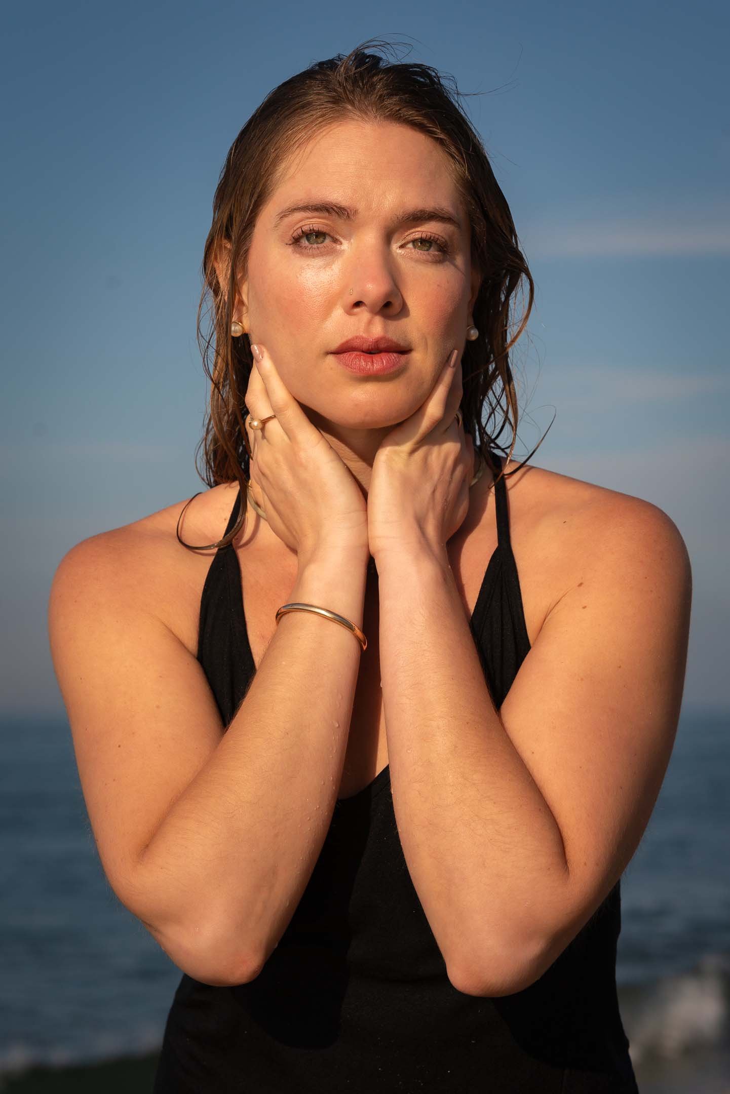 Model wearing gold bracelet and ring at the beach in sunrise in Santa Monica, Los Angeles