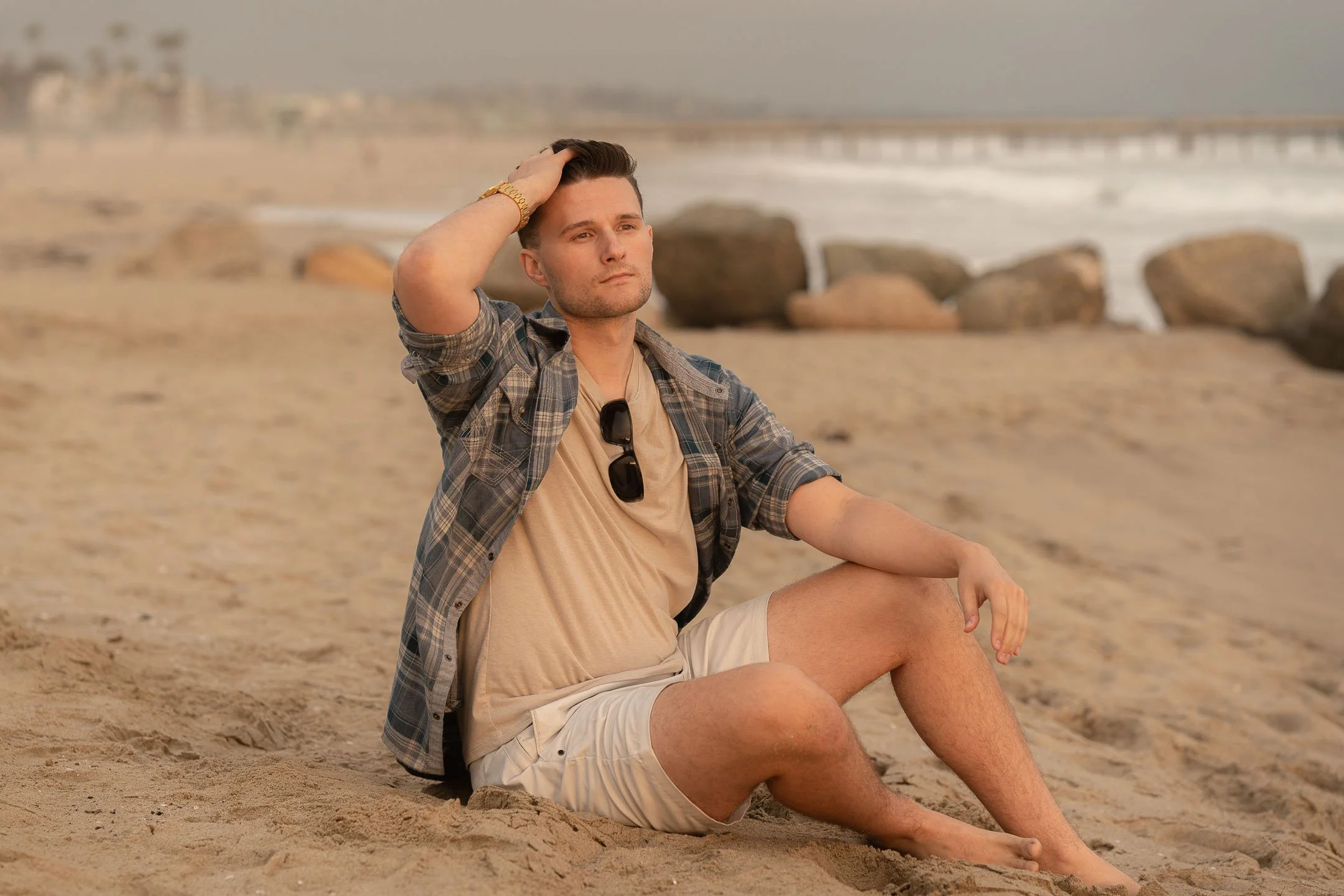 Los Angeles lifestyle model sitting on the sand at Venice Beach during sunset