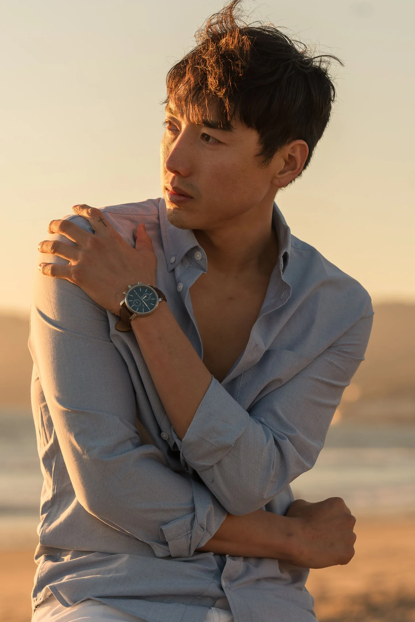 Los Angeles male model posing with blue watch at the beach at sunset