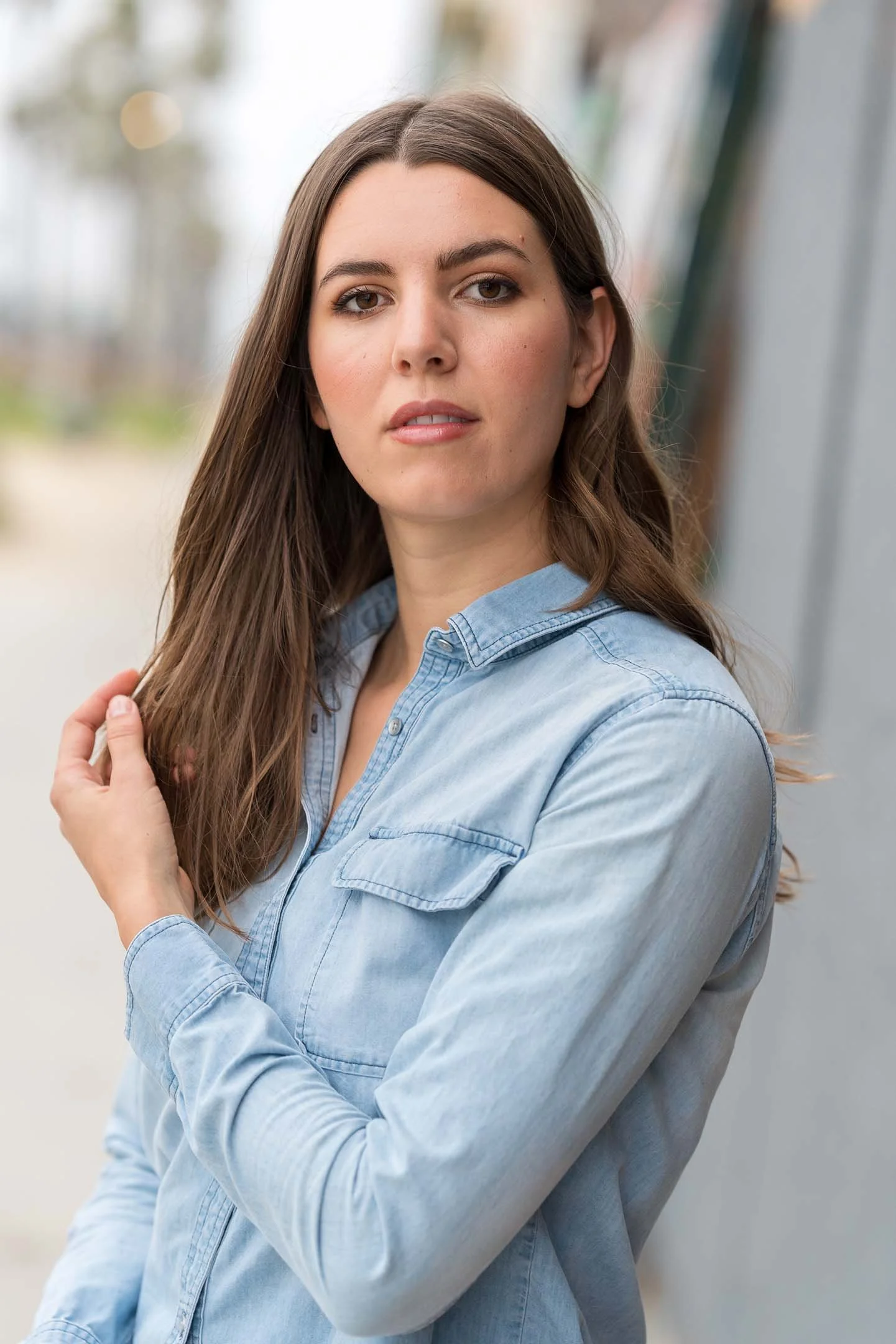 Woman wearing blue denim shirt posing for headshot