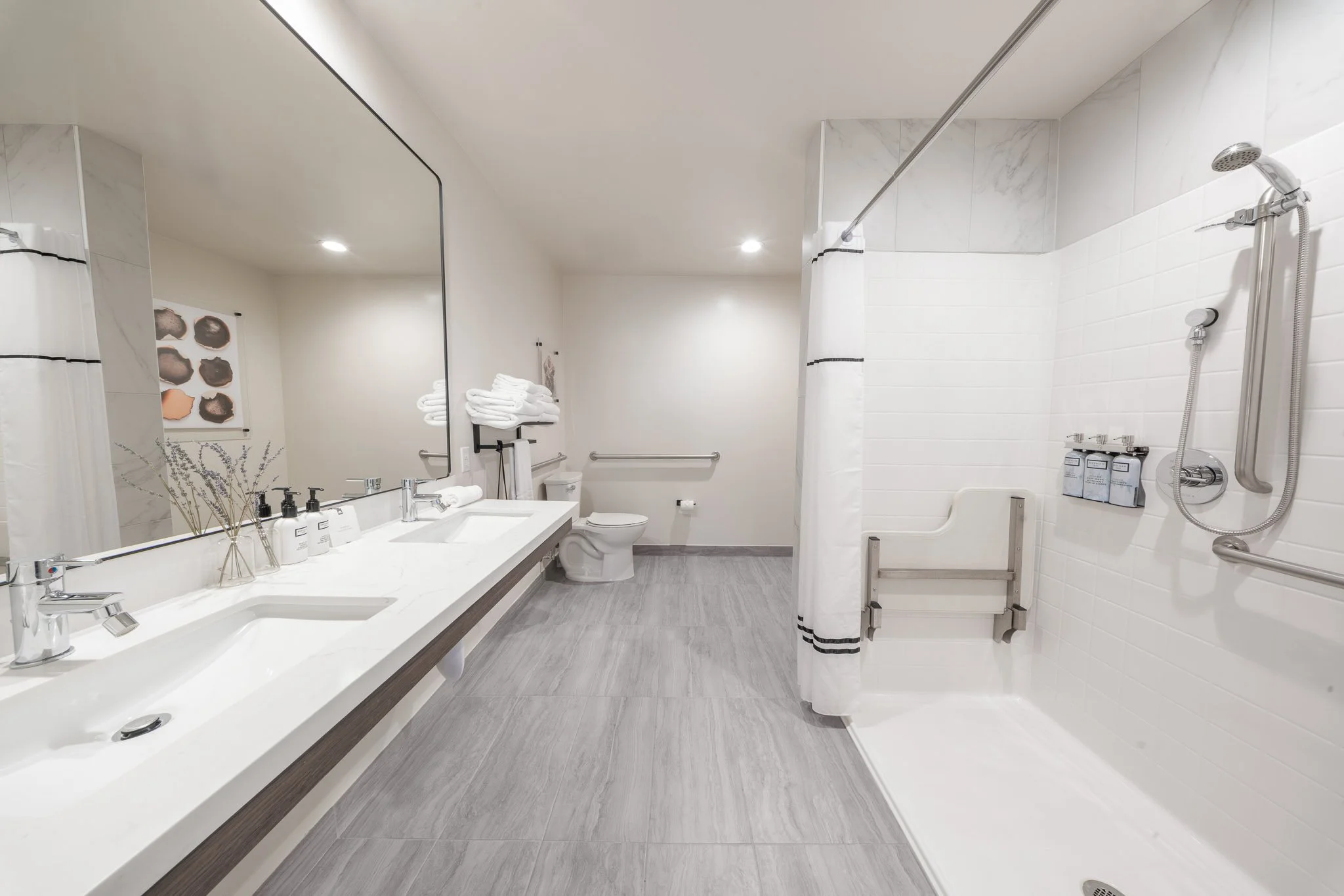 Hotel bathroom with marble walls and tile inside of the bathroom and wooden floors