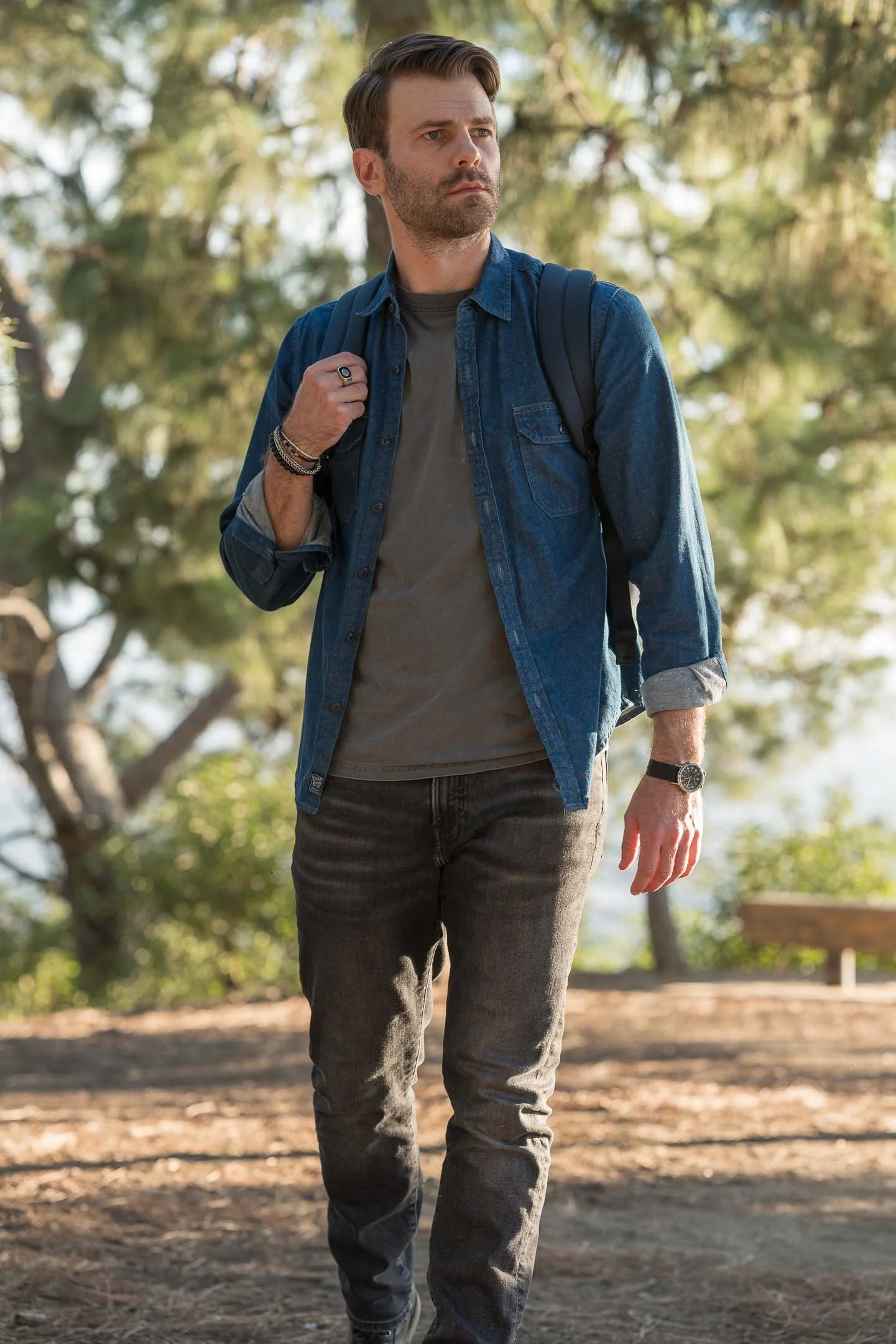 Male model walking along Mount Hollywood wearing backpack and watch