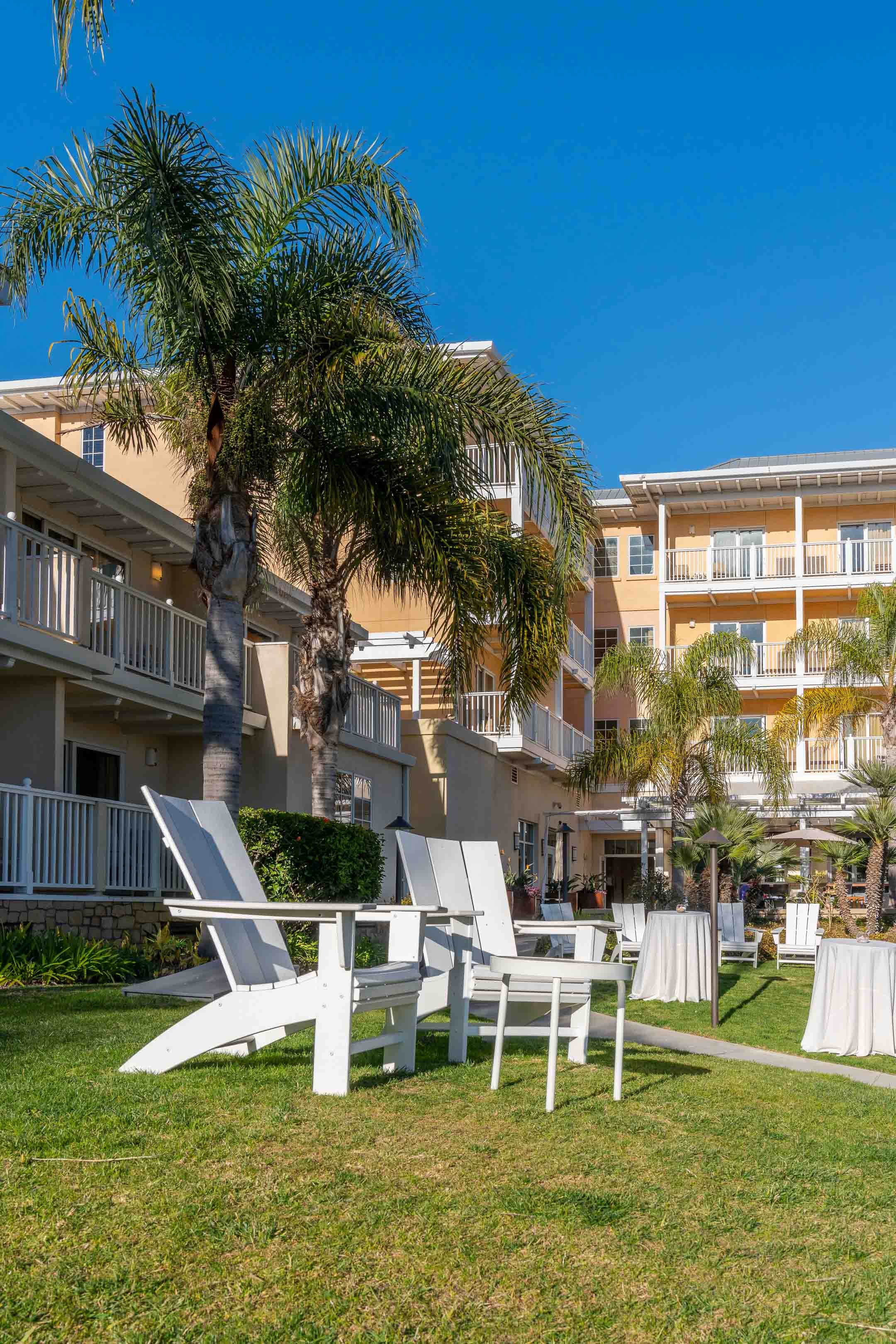 View of the Jamaica Bay Inn with white chairs on the lawn in Marina del Rey