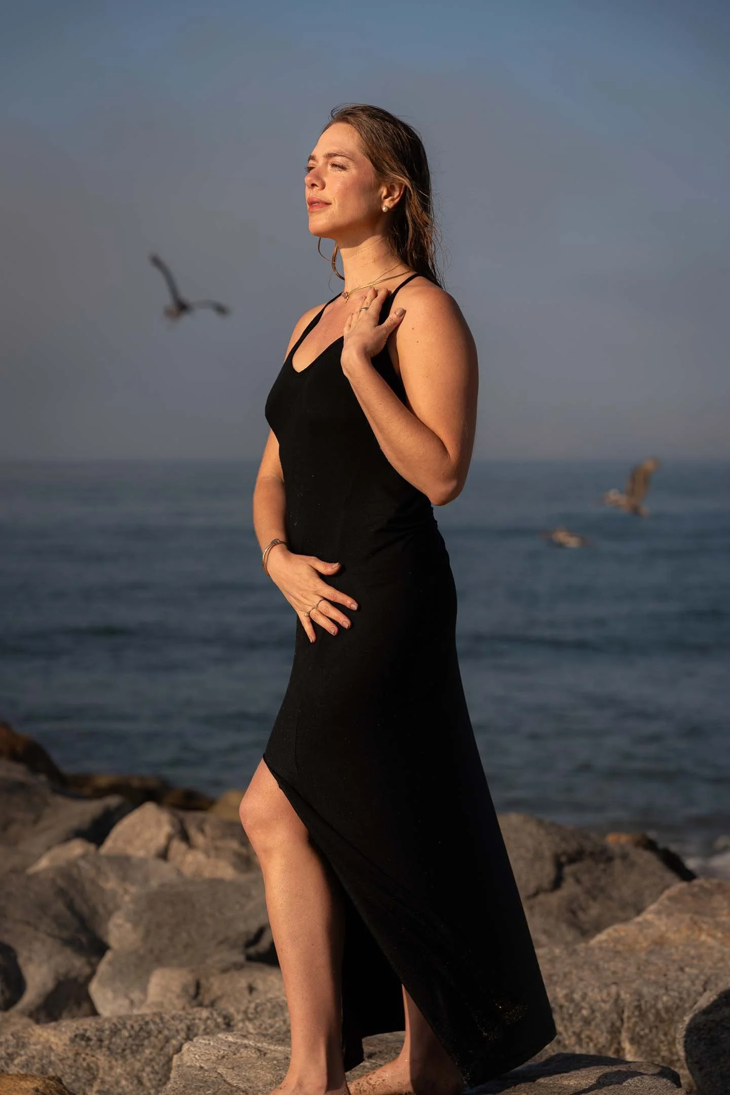 Model posing on the rocks wearing jewelry