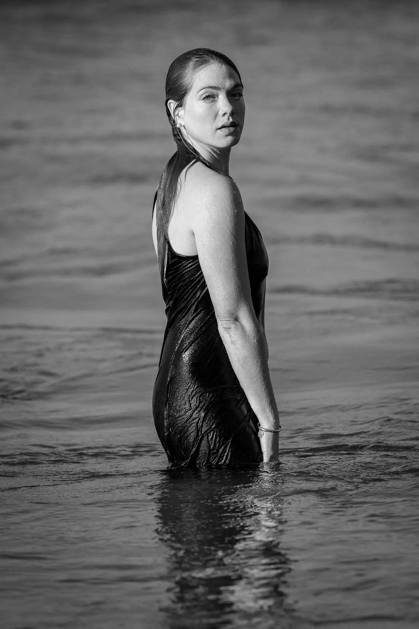 Model posing in the ocean with a black and white photo