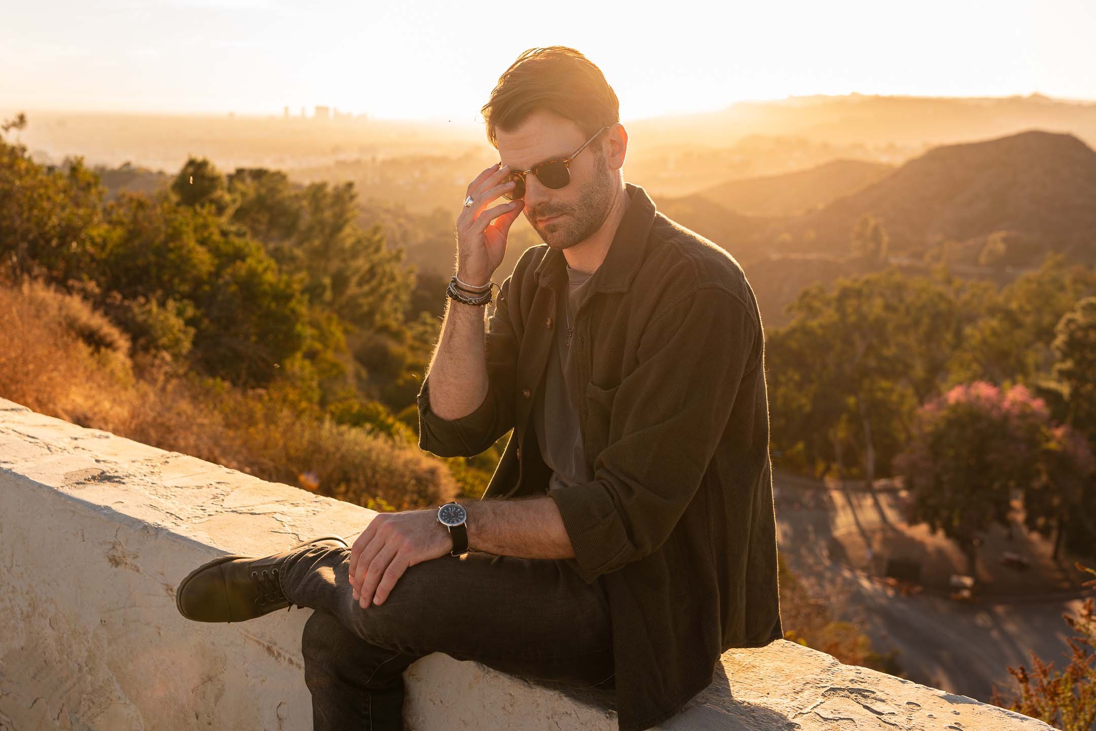 Lifestyle model wearing sunglasses at sunset in front of Mount Hollywood, Griffith Park