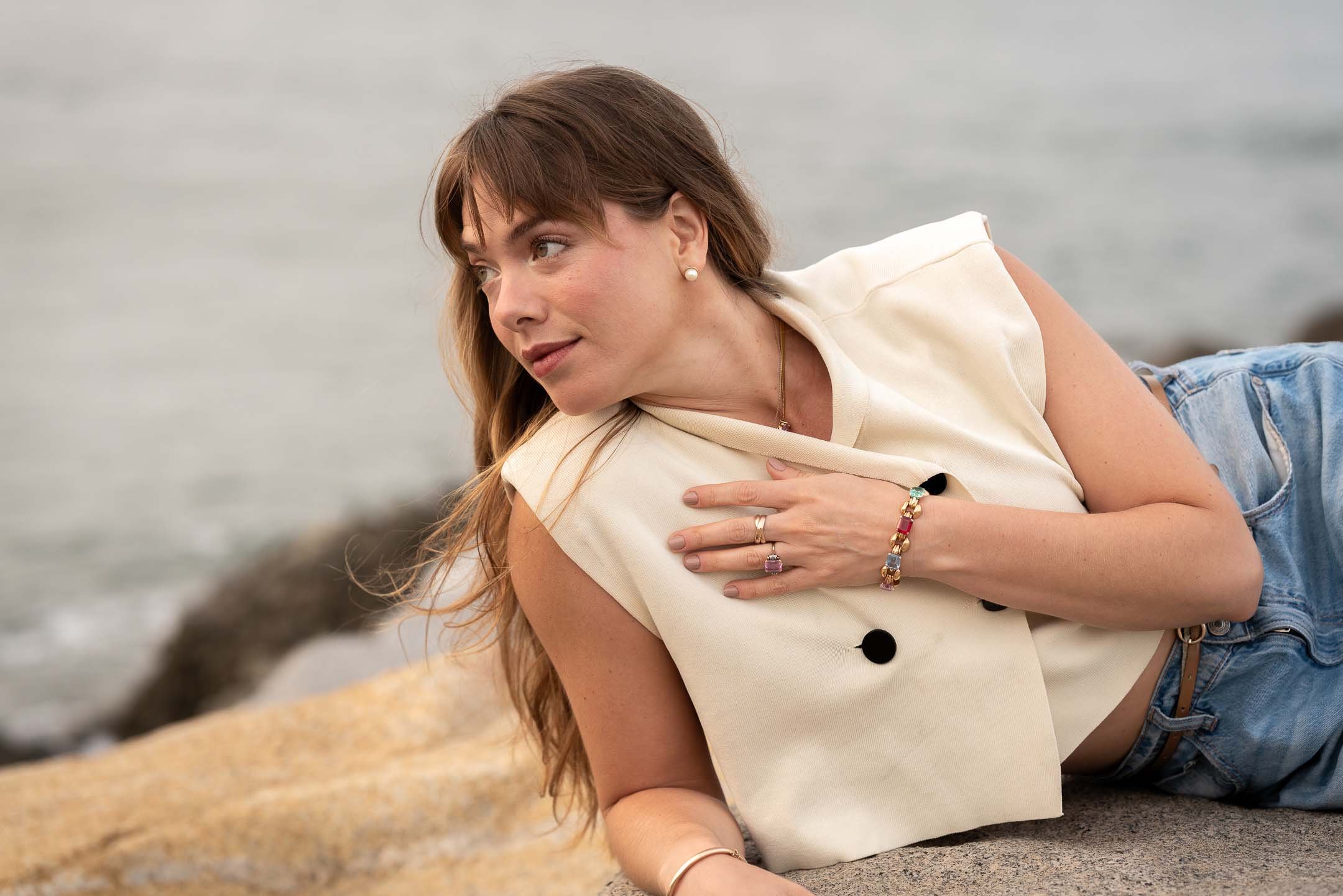 Model posing with colorful jewelry at the beach