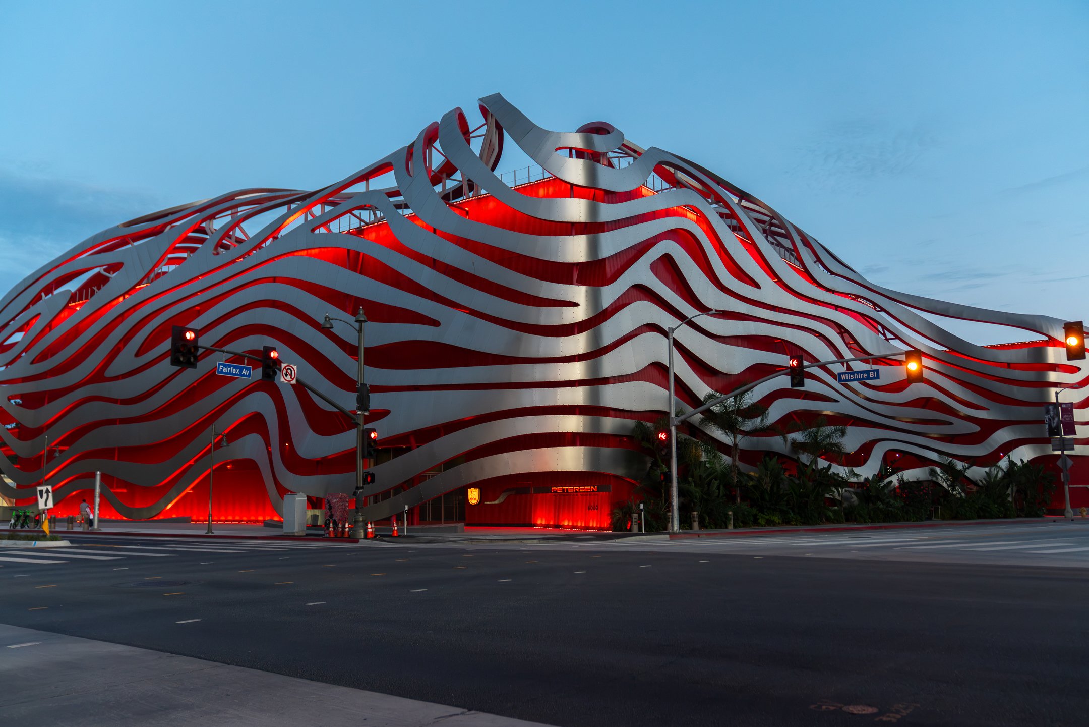 Petersen Automotive Museum at night with greenery on the side of the building