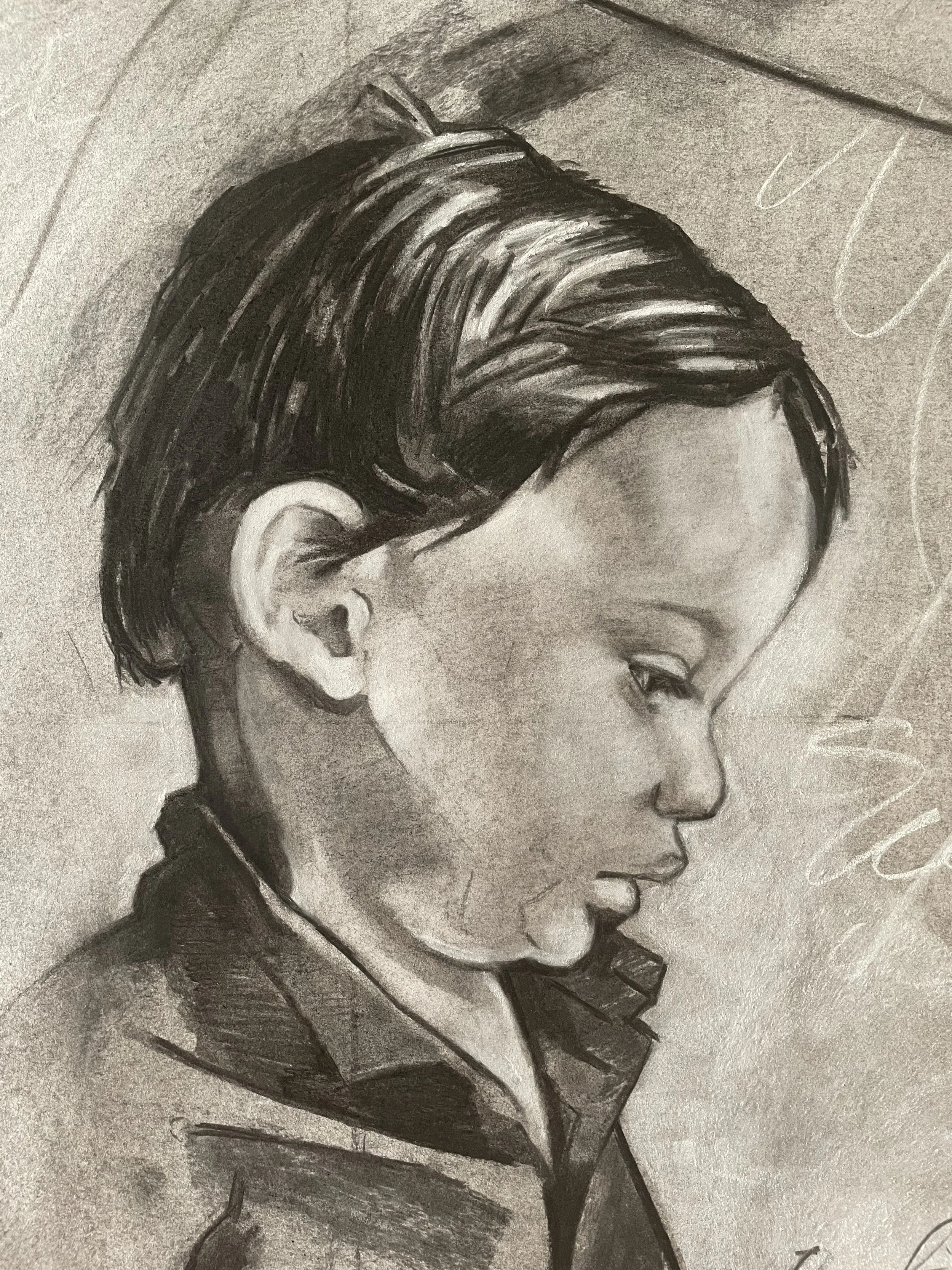 A detailed pencil sketch of a young boy with a short, styled haircut, wearing a jacket, and looking downward.
