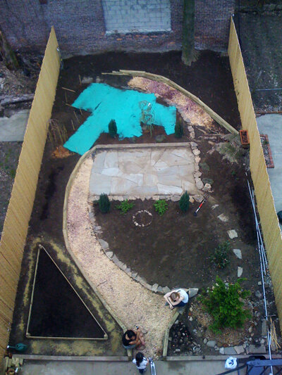 April 2008, first year, retaining walls built, paths constructed and filled with pebbles, triangular raised bed constructed, filled with soil, grass planted and covered in Southern area.