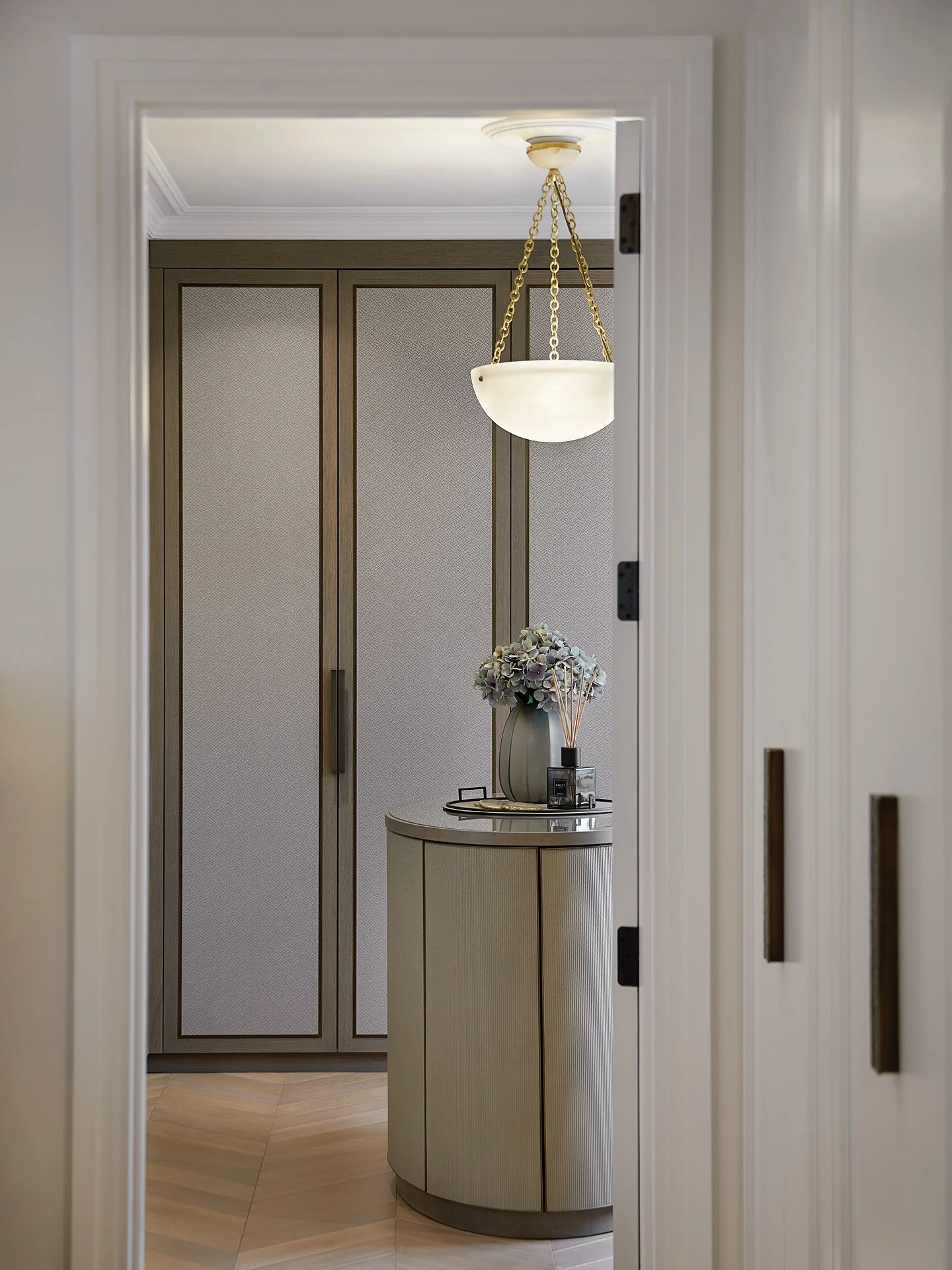 The dressing room from our North London Family Home, calm, refined, and beautifully functional. At its centre, a sculptural oval island anchors the space, complemented by bespoke joinery and a soft alabaster glow. 
.
.
.
#interiordesign #luxuryhomes 