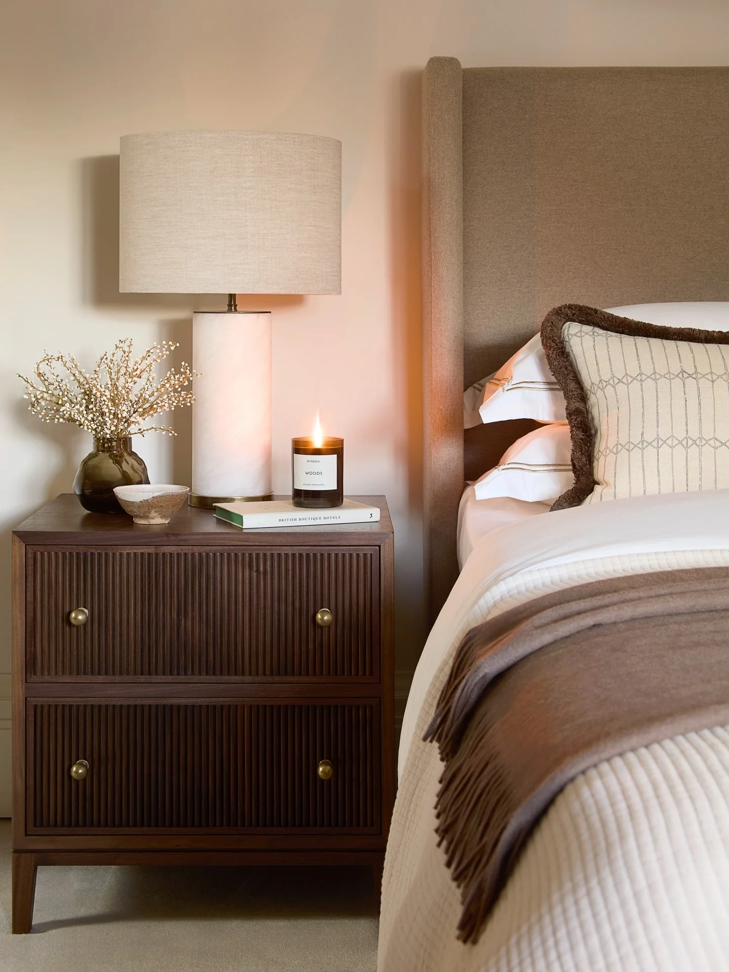 A quiet vignette from one of the guest bedrooms at our Hampstead project. Clean lines are softened with layered neutral tones. I personally love the dark timber bedside table, with its reeded detailing and brass handles. Swipe left to view the readin