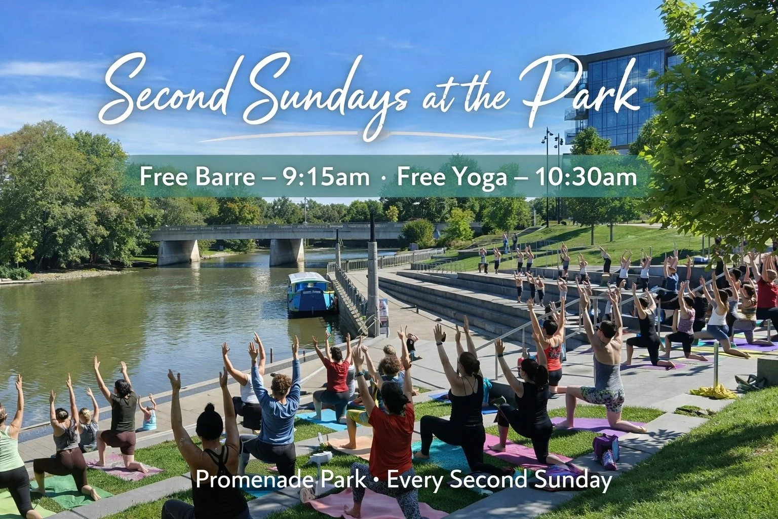Group of people practicing yoga outdoors on a sunny day near a river with trees and a modern building nearby.