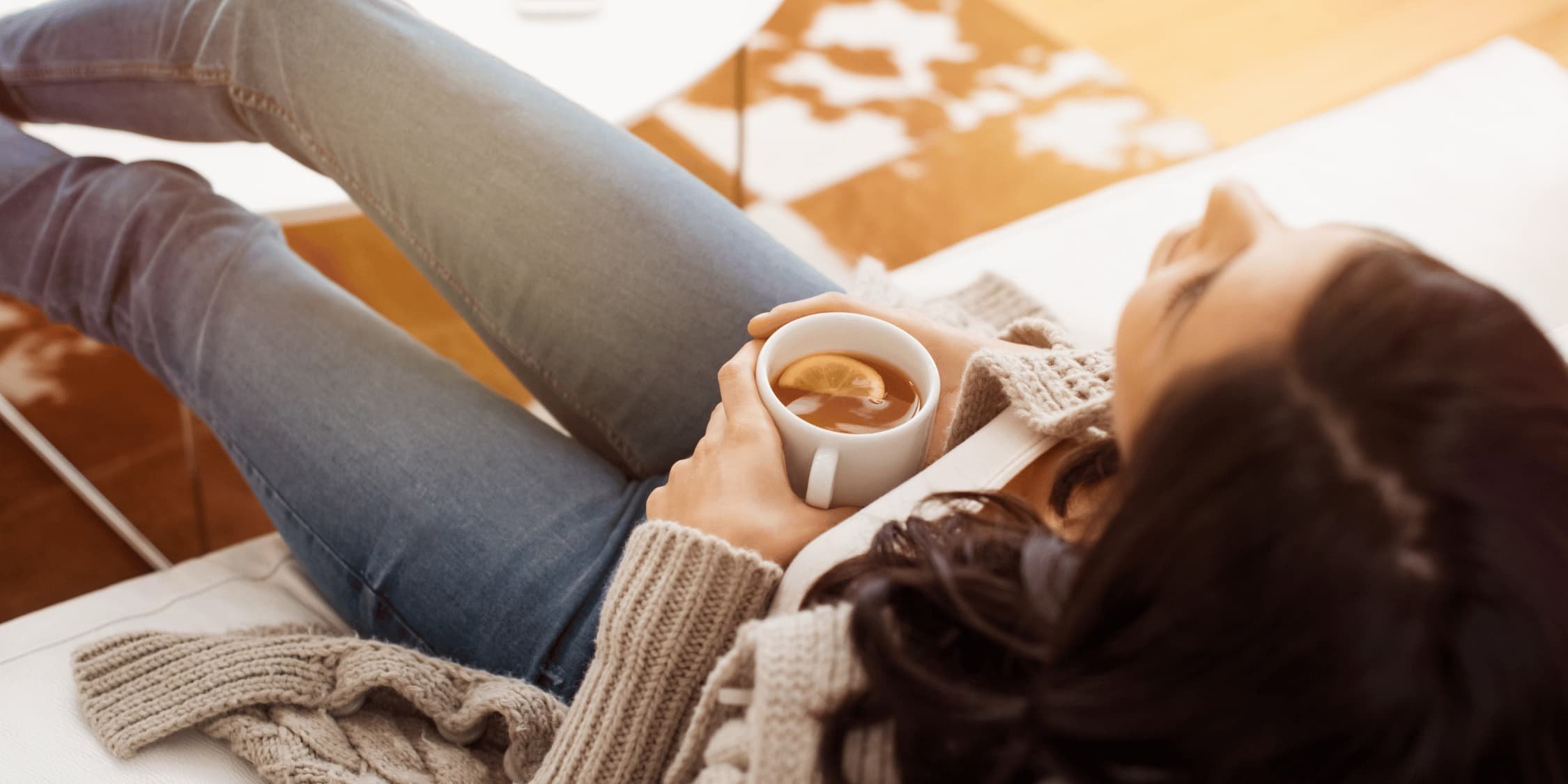 Woman relaxing while holding a tea with lemon