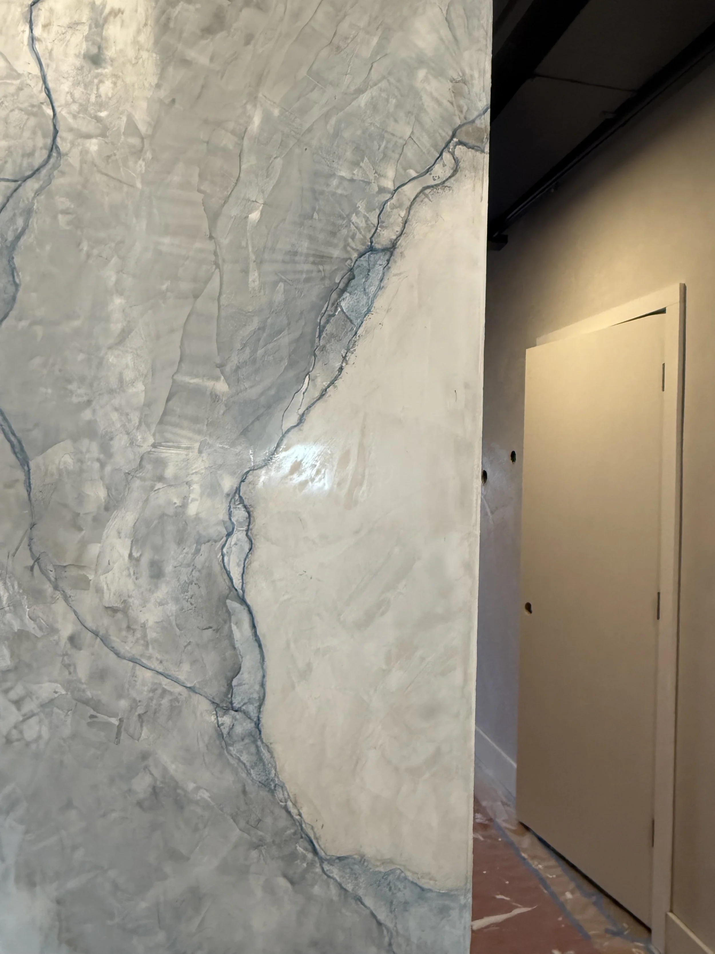 A wall with a marble texture and prominent dark blue veins.