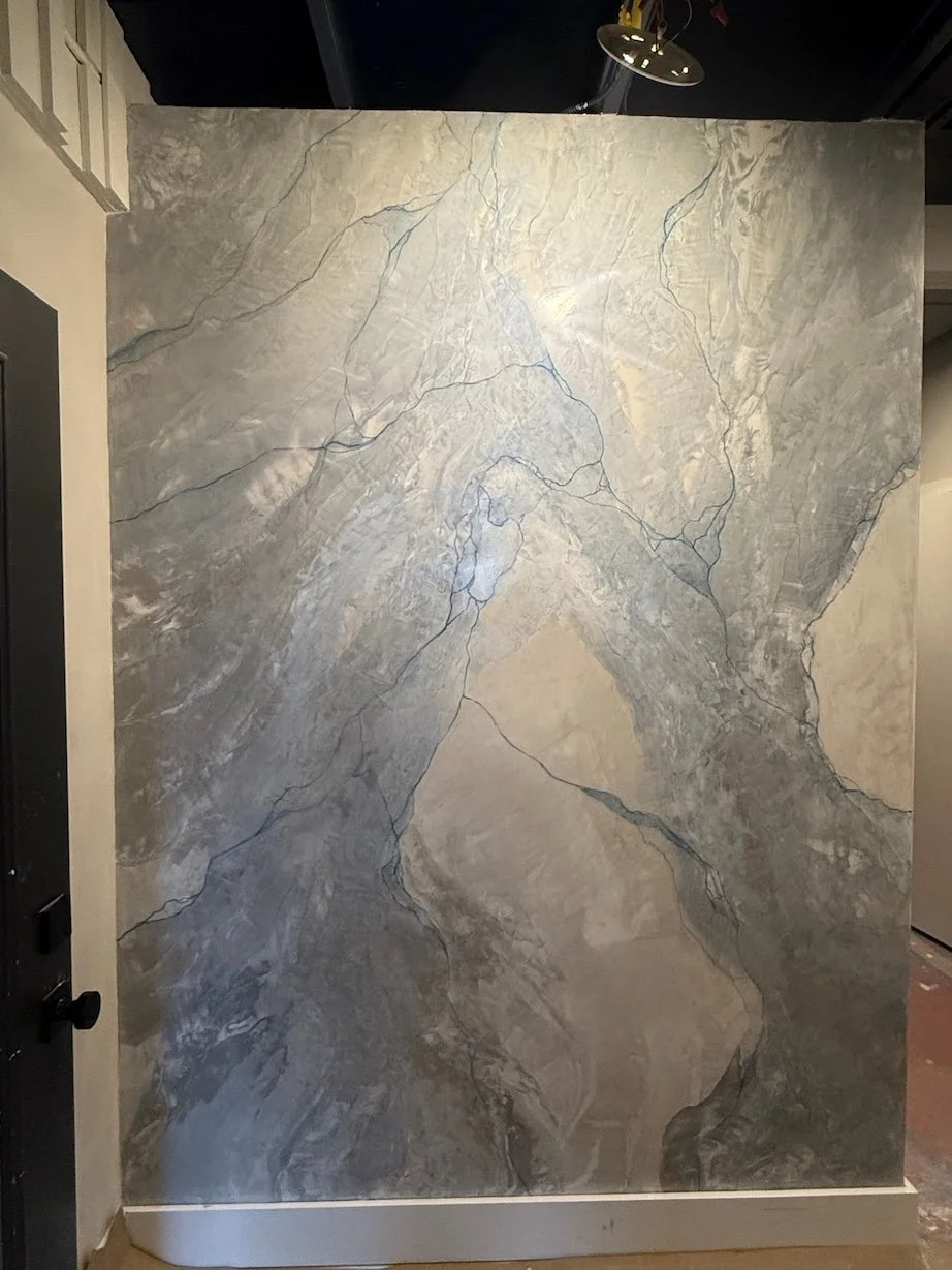Marble wall with gray and beige veining patterns in an indoor setting.