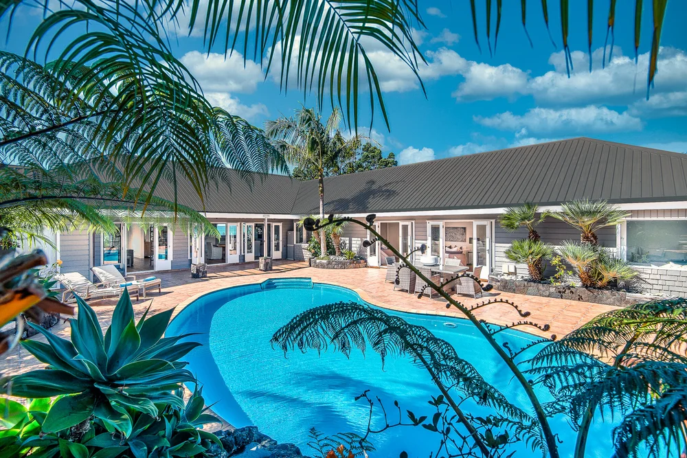 Swimming pool and palm trees beside the Sandspit home.