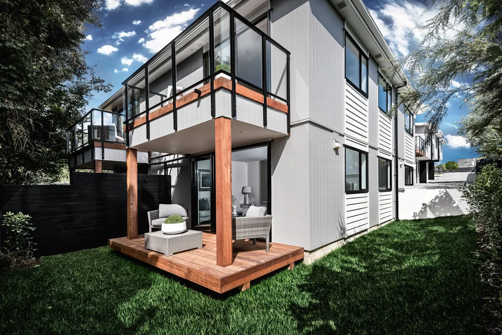 Townhouse with a glazed upper balcony and sheltered ground-floor terrace.