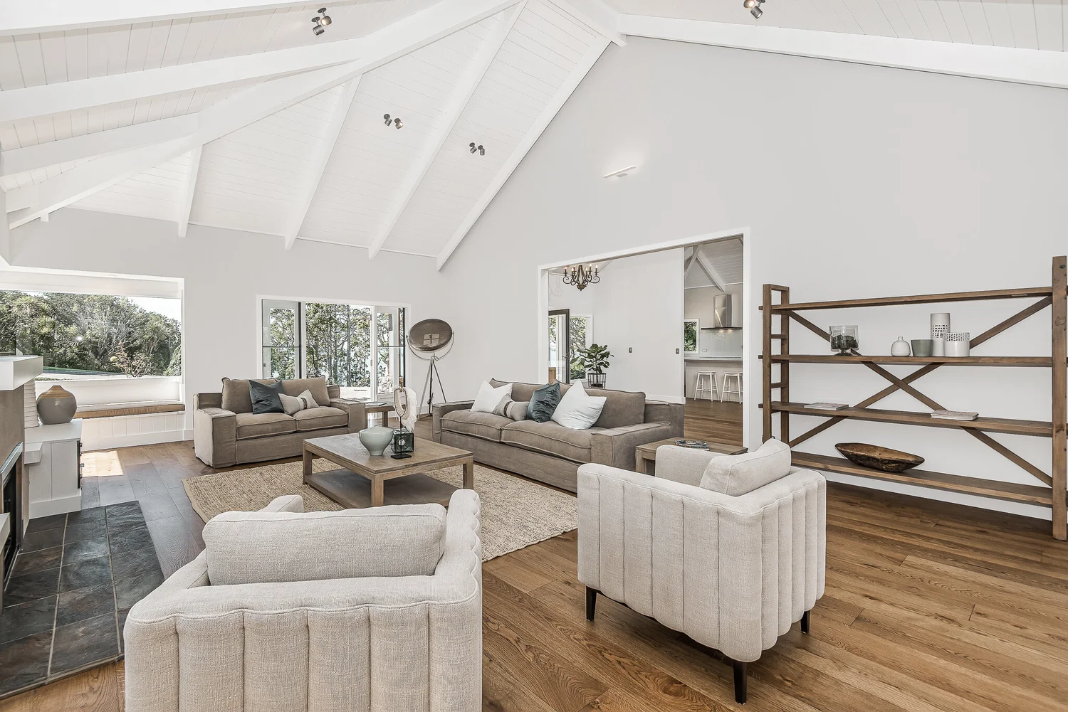 Light-filled living room with pale seating and vaulted ceiling in Sandspit.