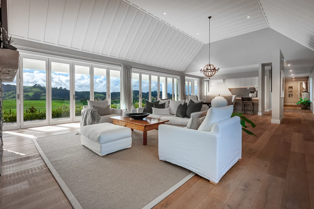 White sofas, a timber coffee table and natural textures in the Matakana Hills living room.