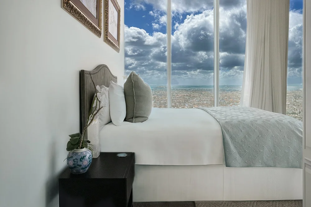 Bedroom beside large windows overlooking the coast.