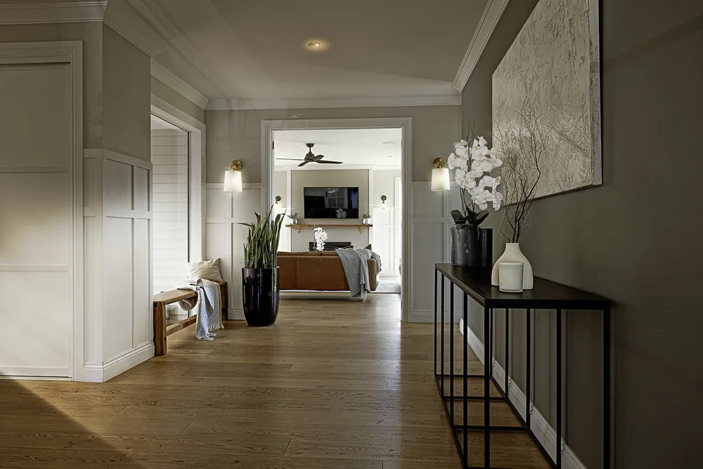 Coatesville hallway with a slim dark console, artwork and decorative accessories.