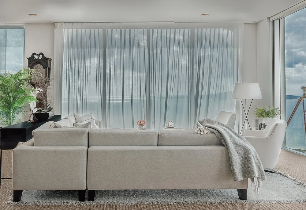 Rear view of the Takapuna sofa beside full-height curtains.