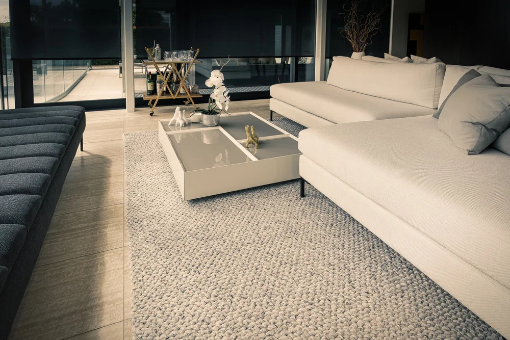 Living room seating arranged around low pale coffee tables.