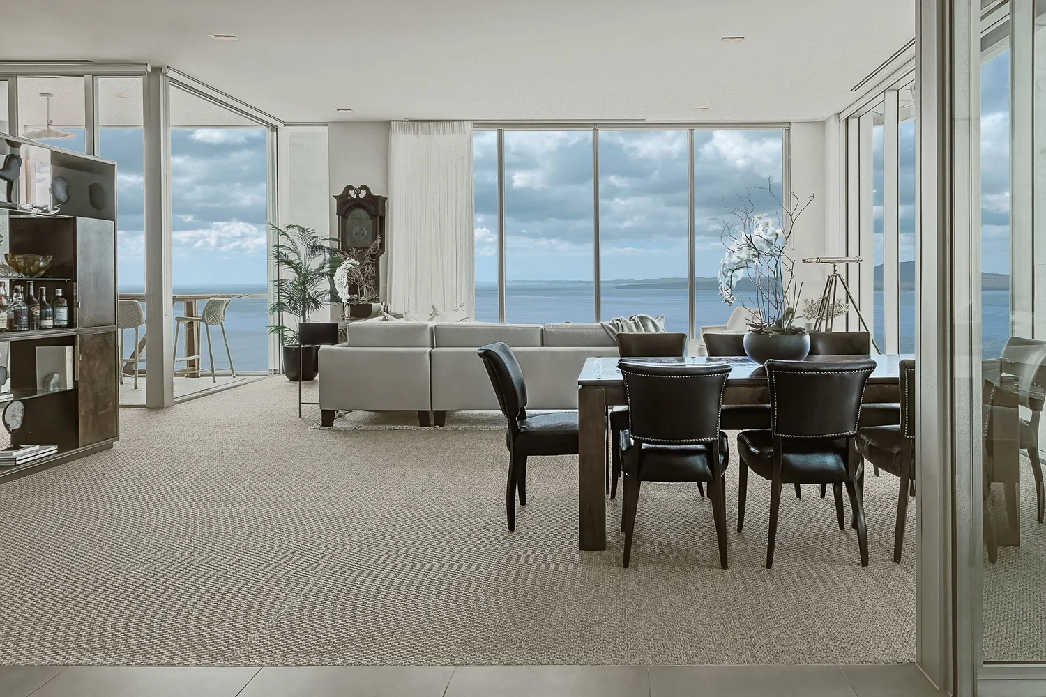 Living and dining spaces in the Takapuna apartment, with bespoke furnishings and ocean views.