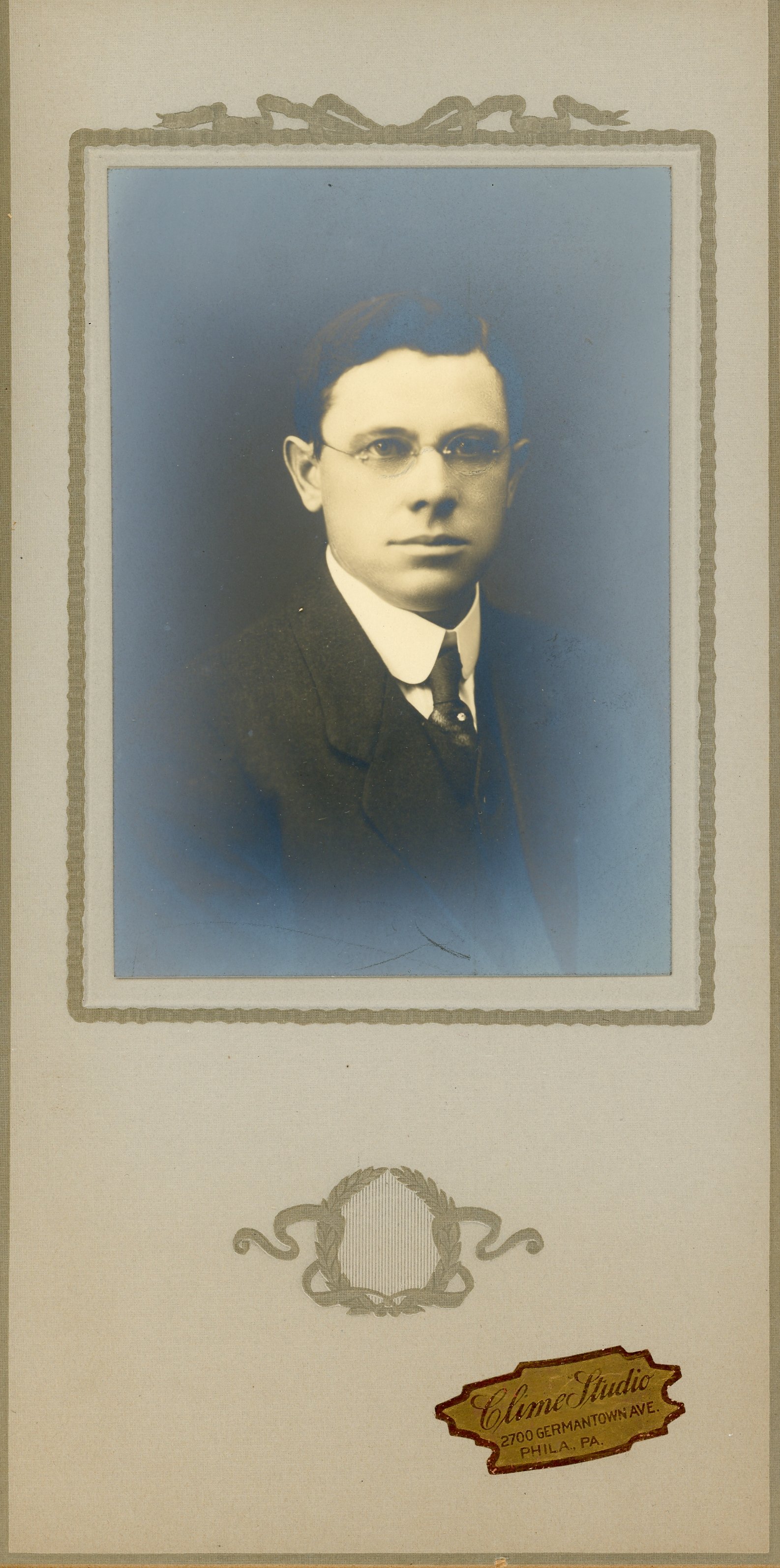 Vintage portrait photograph of a man in a suit and glasses, with a decorative border and Clime Studio logo, Philadelphia, PA.