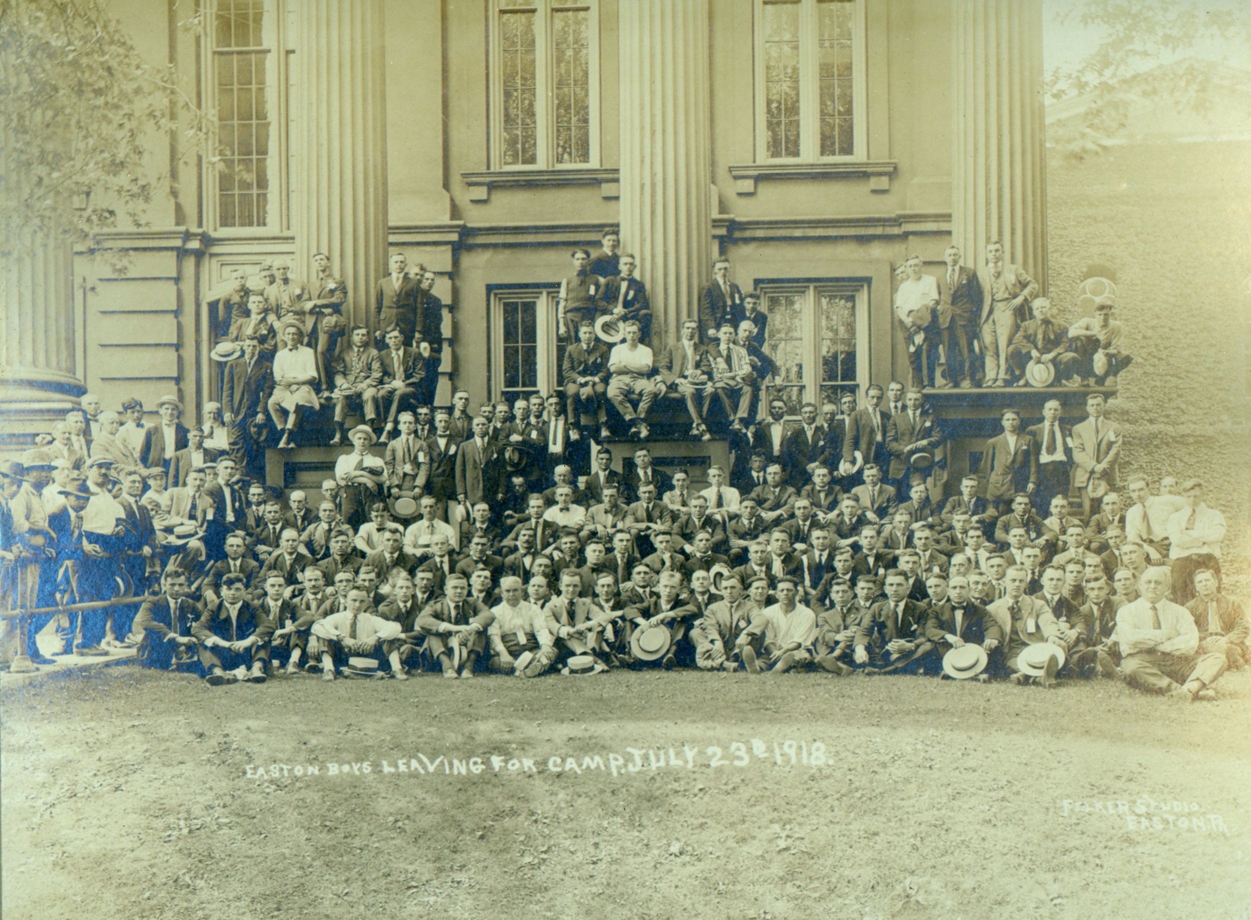 Historical group photo of men in suits and hats, Easton 1918, gathered in front of building with columns.