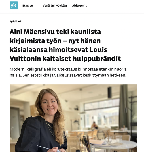 Lehtiartikkeli, jossa kuva missä Aini Mäensivu istuu sisätiloissa, hymyilee ja pitelee kalligrafiavälineitä. Teksti puhuu kalligrafiasta ja tunnetuista brändeistä.
