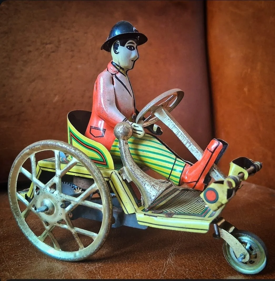 Vintage tinplate driving man on trick cart,