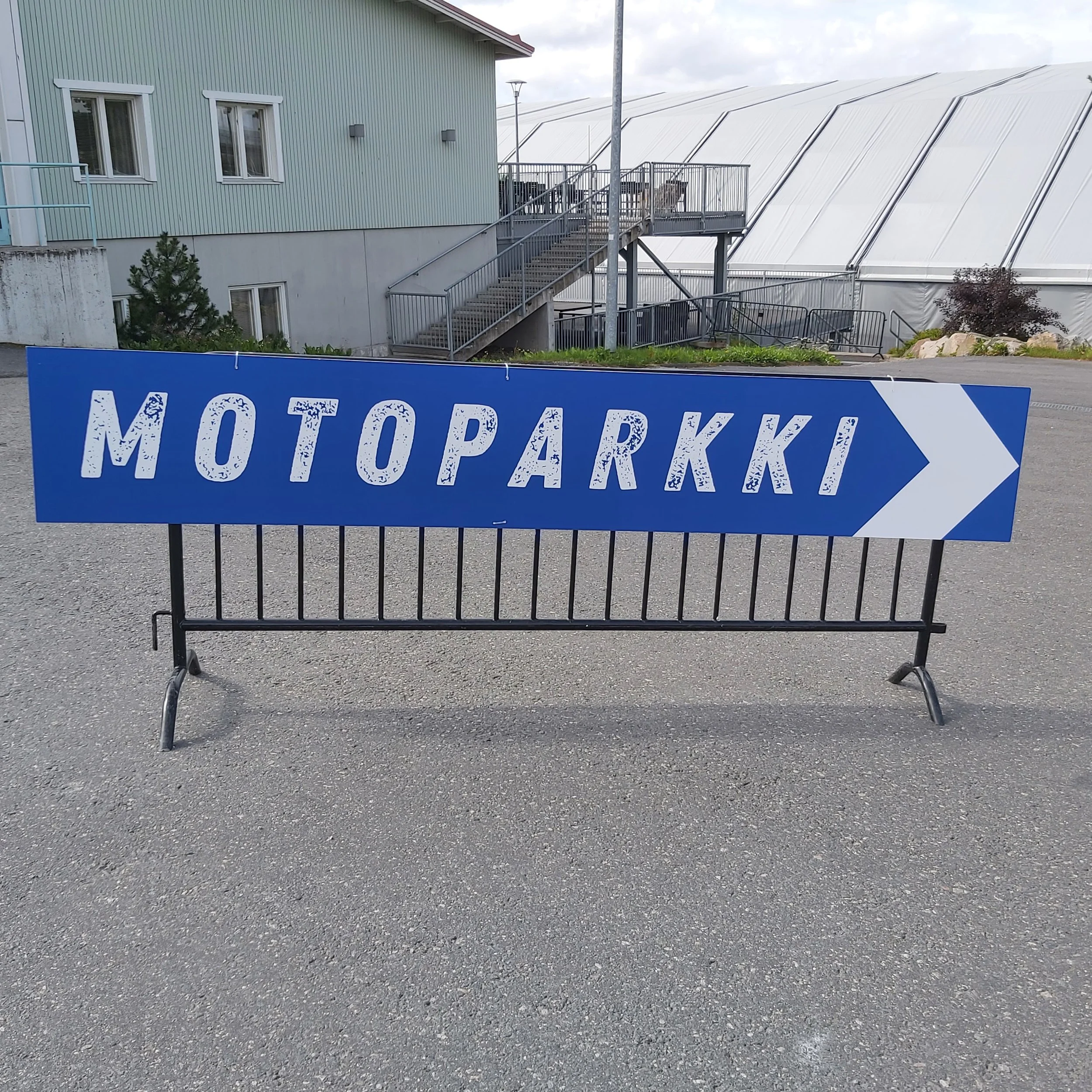 Liikennemerkki, jossa lukee 'Motoparkki' ja osoittaa oikealle.