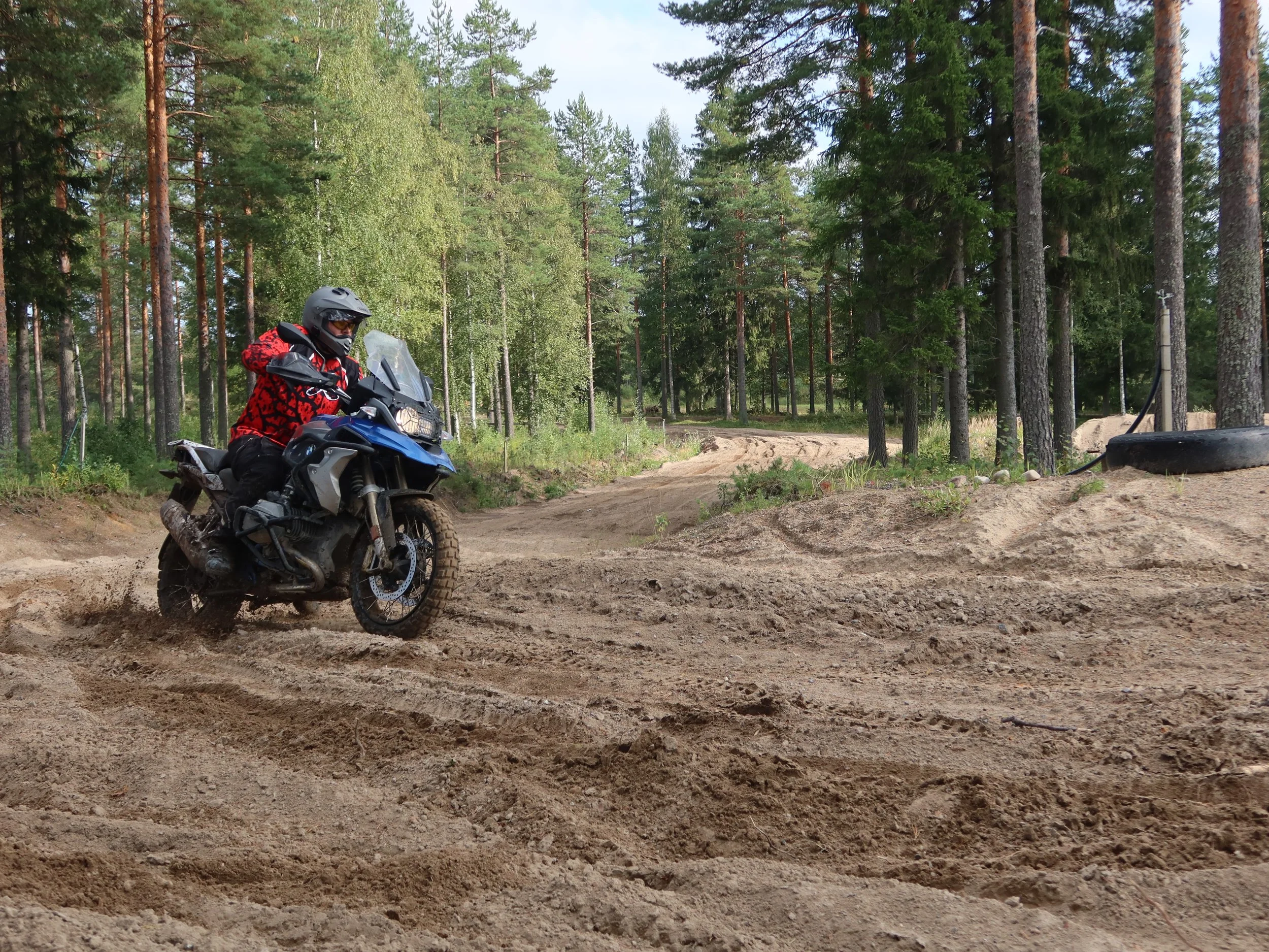 Motoristi ajaa off-road-reittiä metsässä.