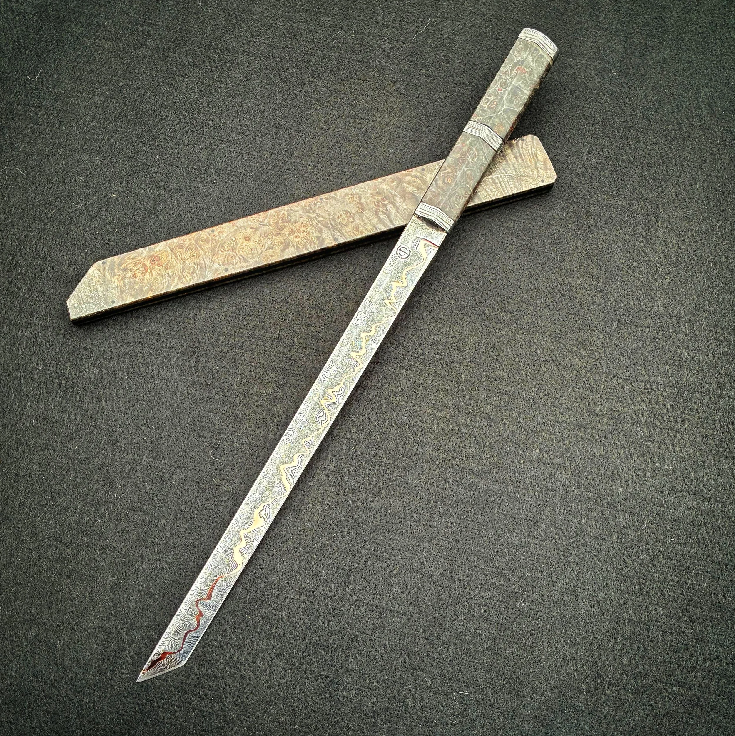 ornate carving knife, placed on a black surface.