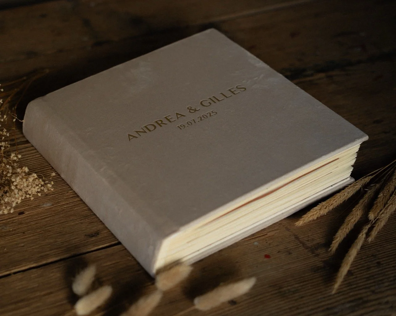 Hochzeitsalbum liegt auf Holztisch.