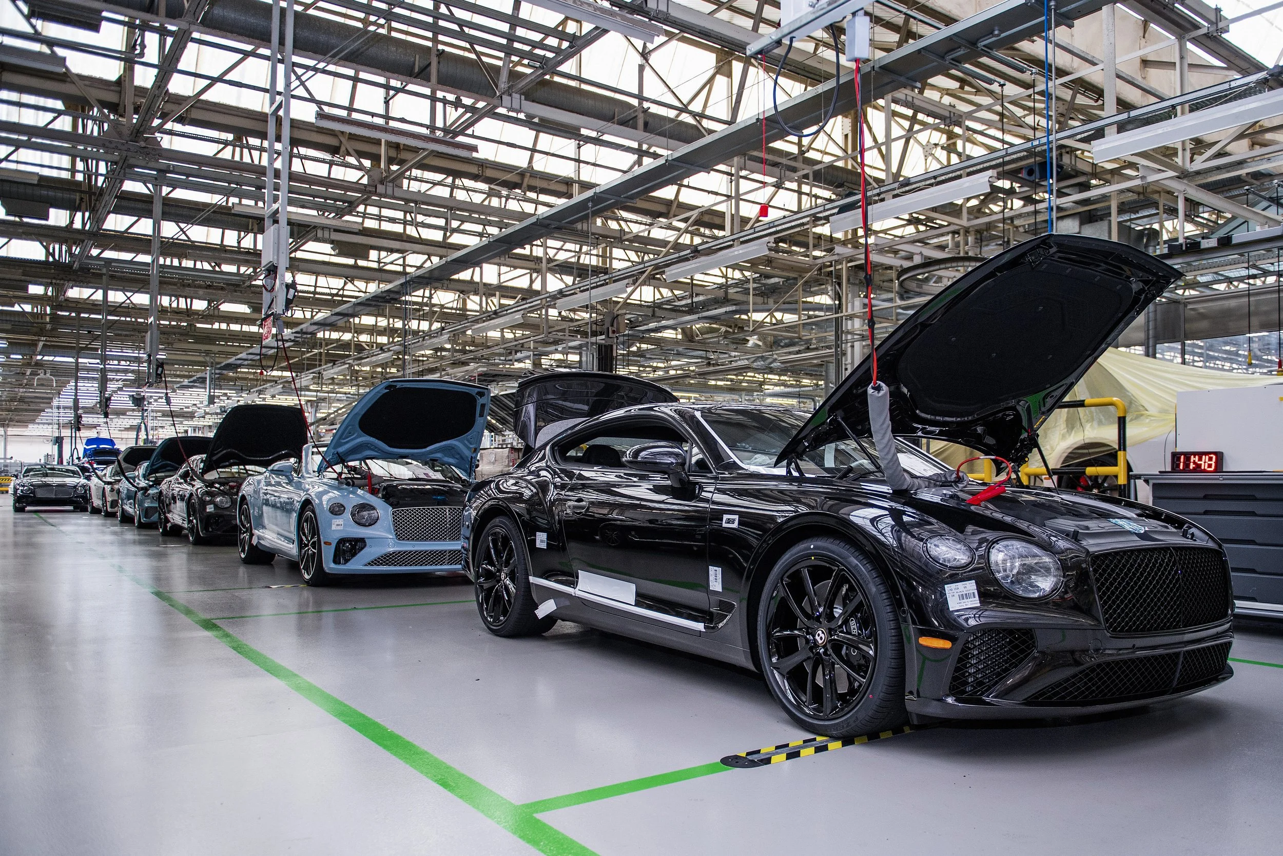 Bentley production line with workers assembling luxury vehicles in factory