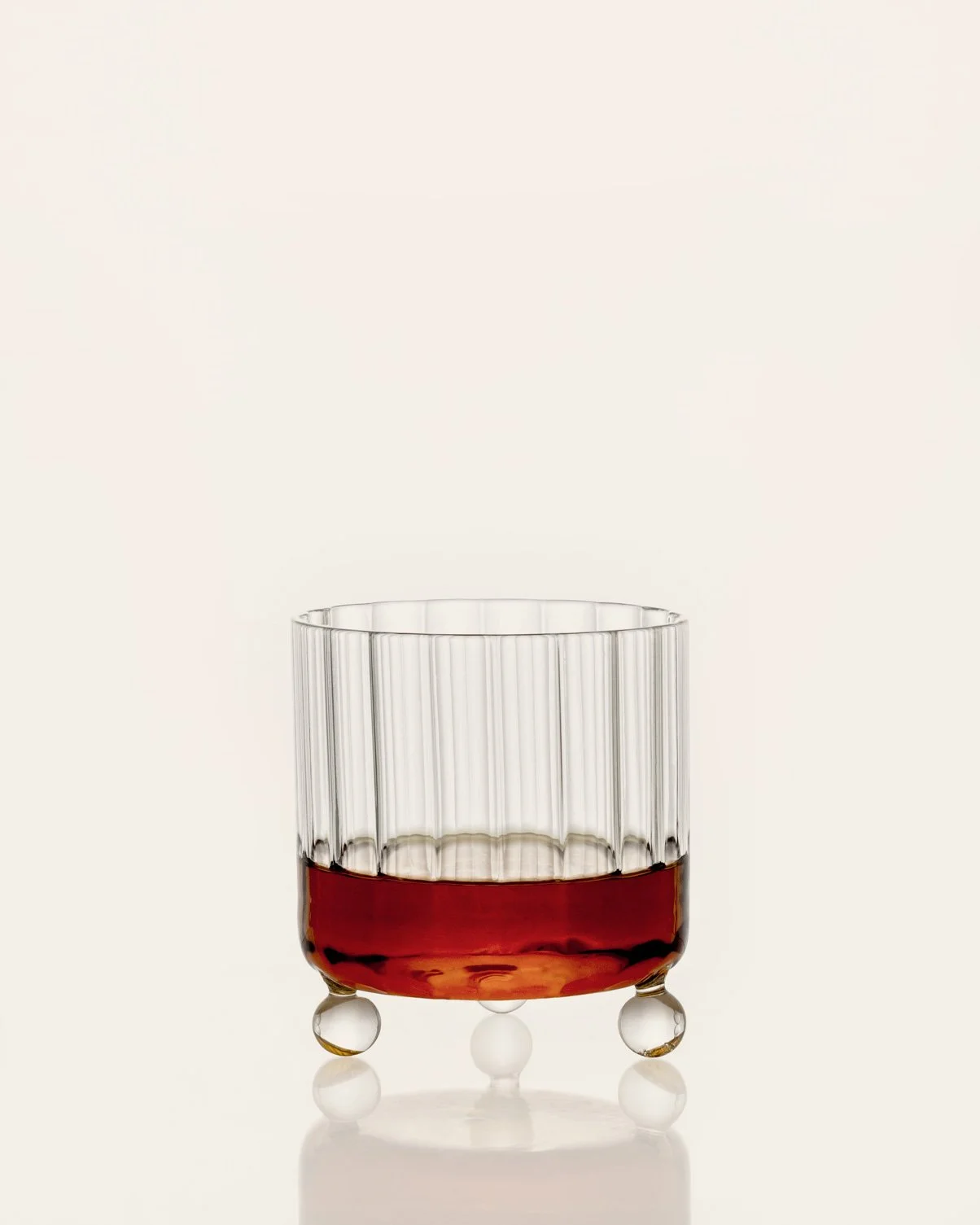 Designer glassware by Agustina Bottoni. Contemporary unique design. Tumbler glass with whisky. Handmade in Italy.