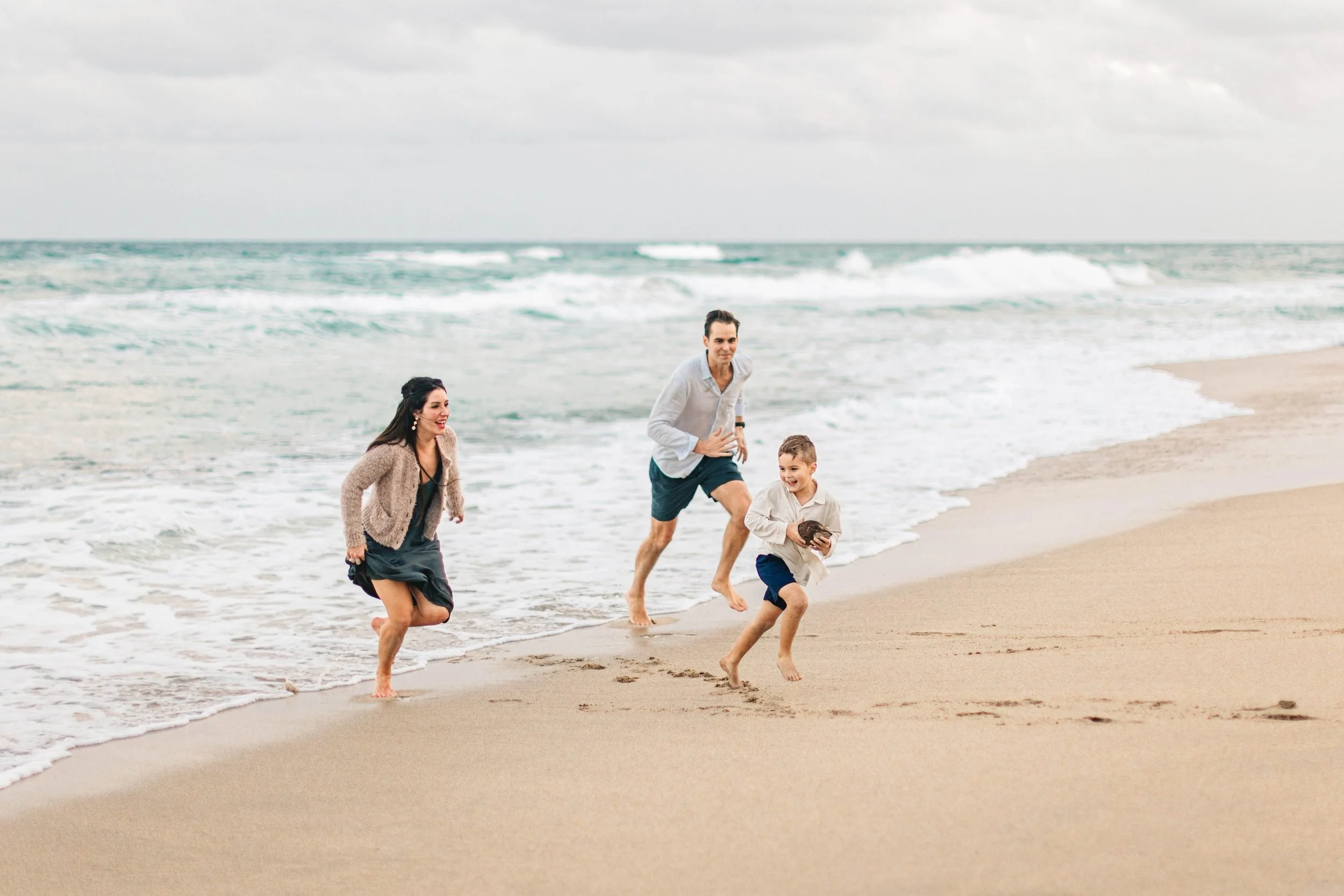 Family running together along the beach in Delray Beach