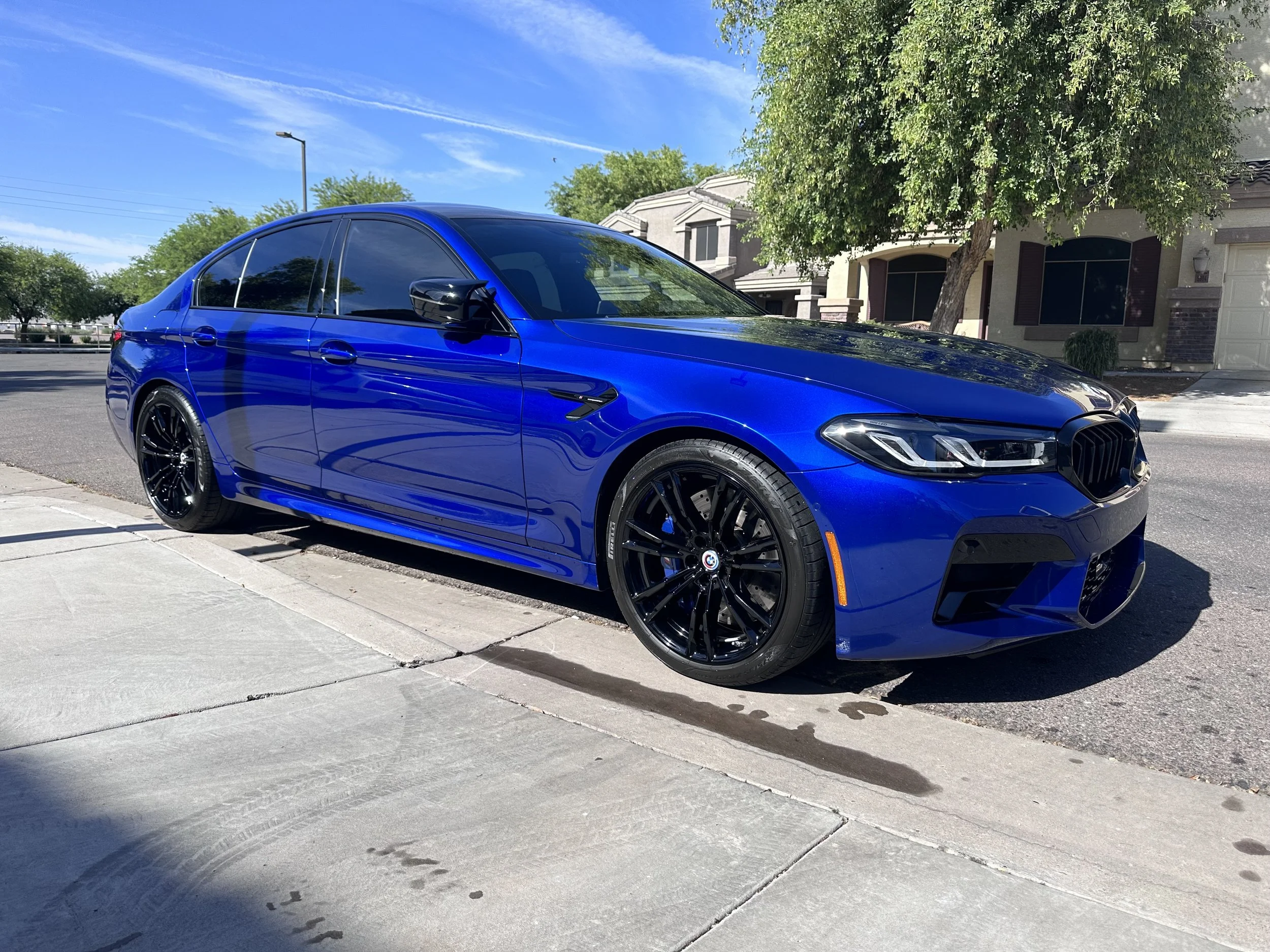 Blue BMW M5 Competition shimmering in the sun on the street after a maintenance detail in Buckeye, AZ