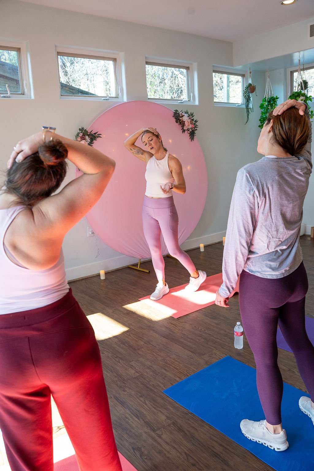 Coach Lisa leading a standing stretch with two retreat attendees