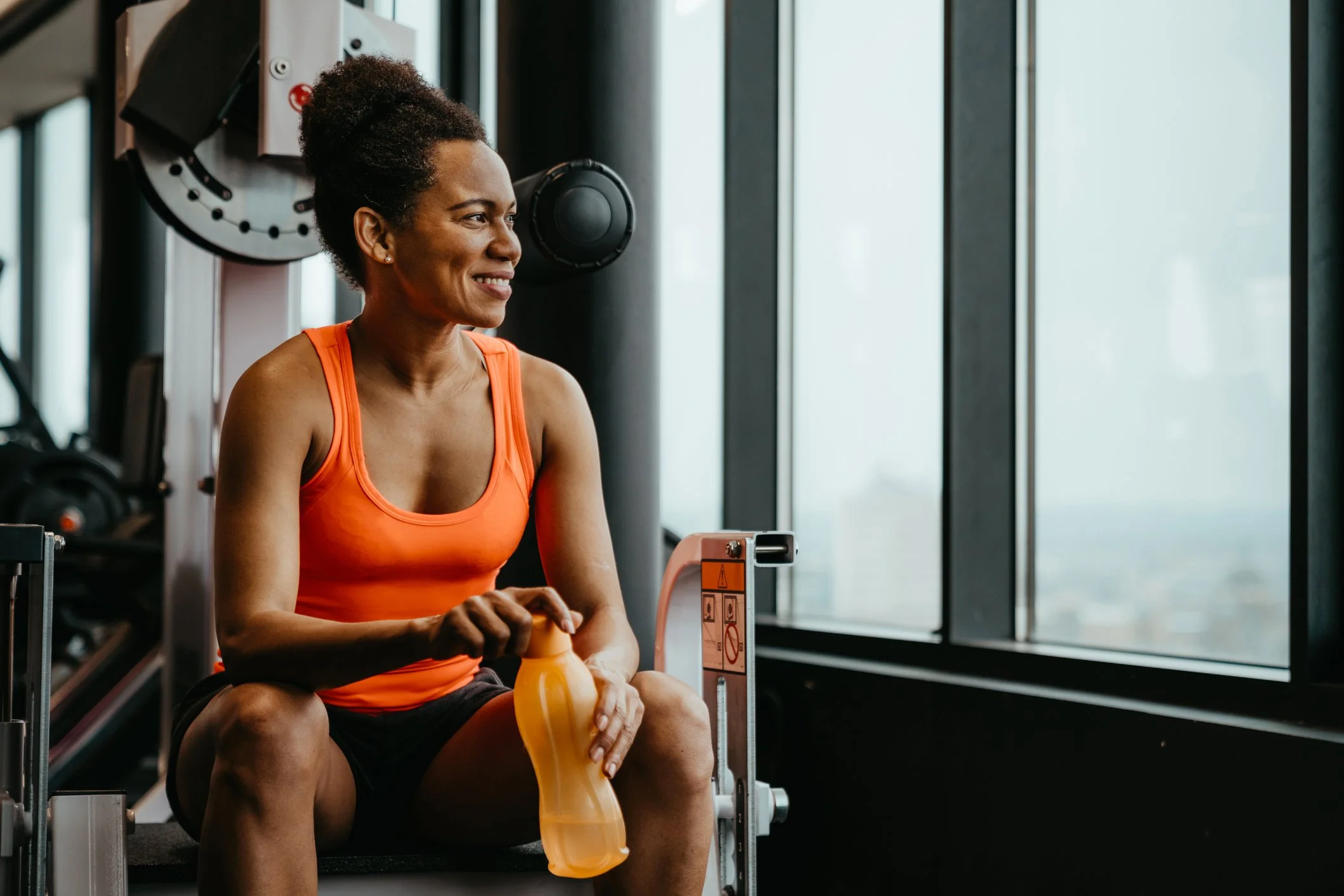 Strong woman sitting on a bench at the gym