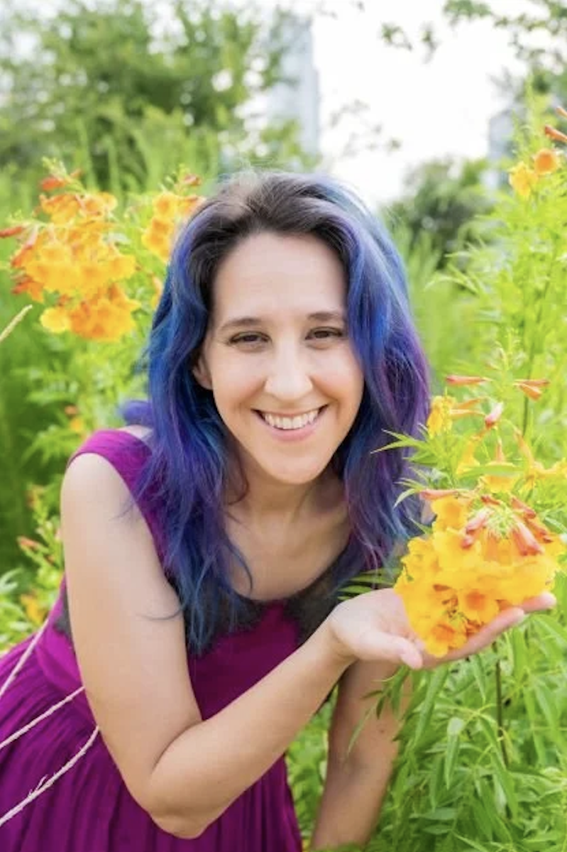 Nikke Seals in a pink dress, in a field of yellow flowers
