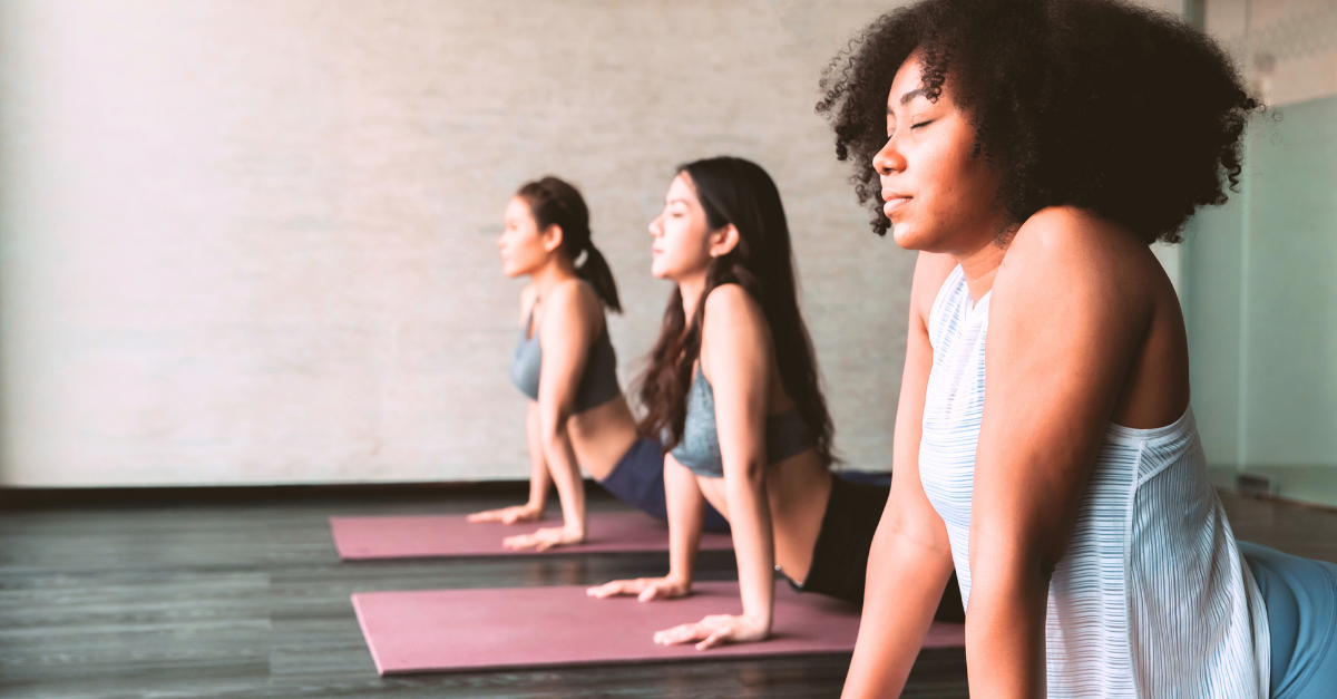 Three women doing yoga on yoga mats