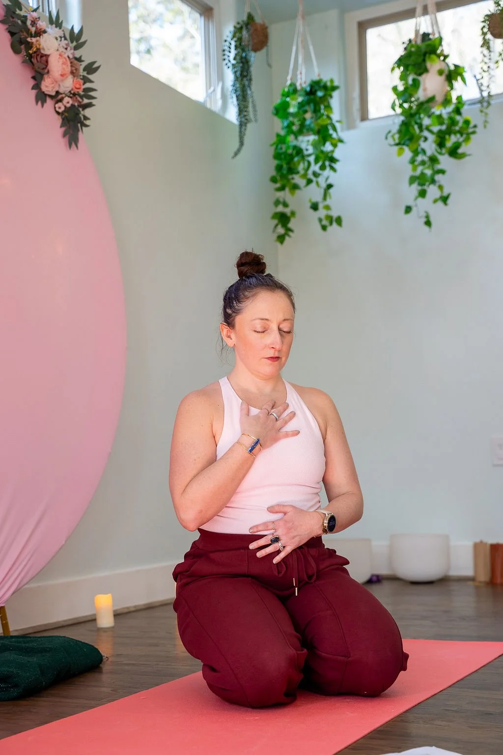 Katie Porras kneeling with a hand on her heart during a sound healing session