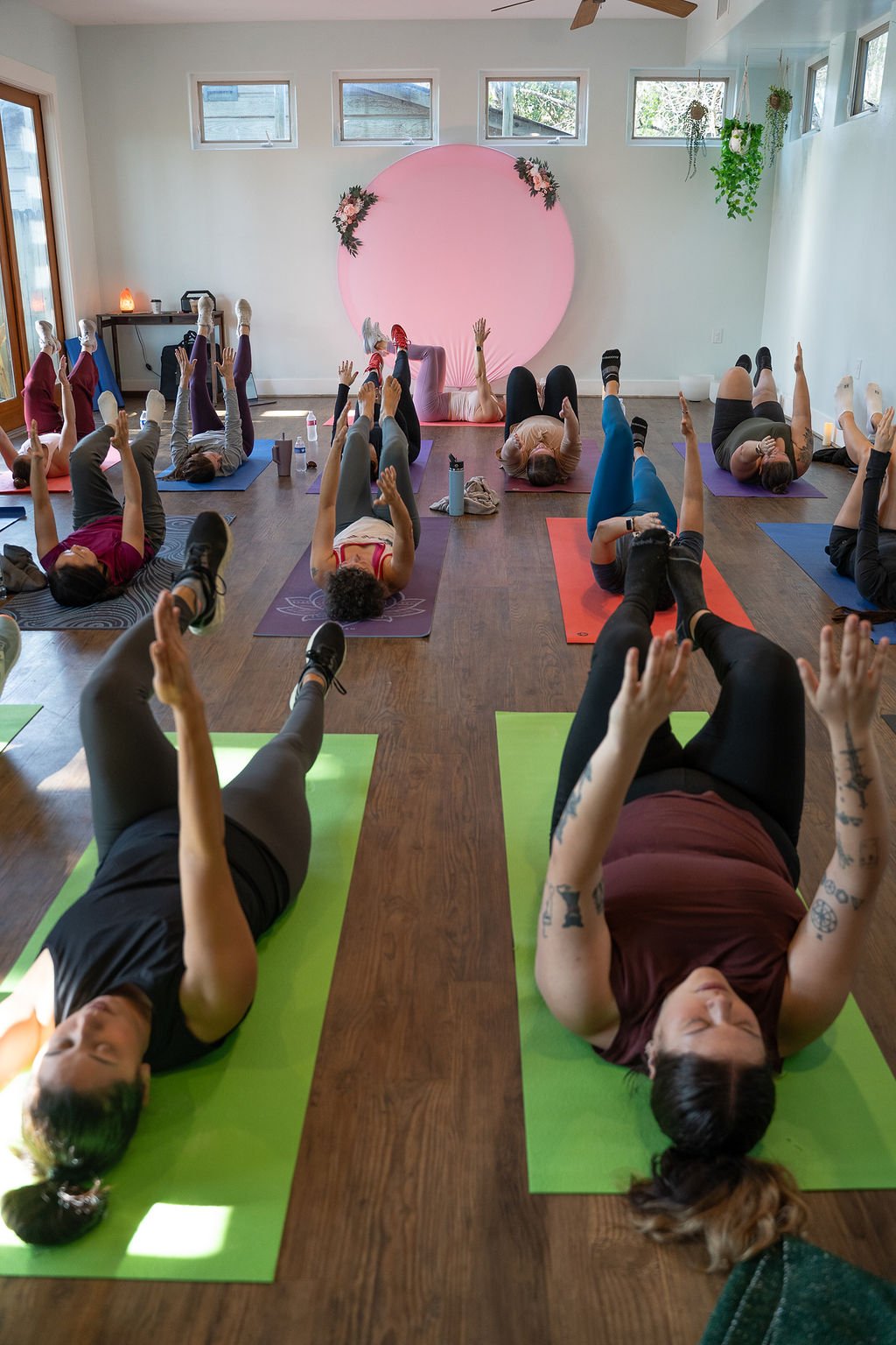 Retreat attendees lying on mats with legs raised during a stretch